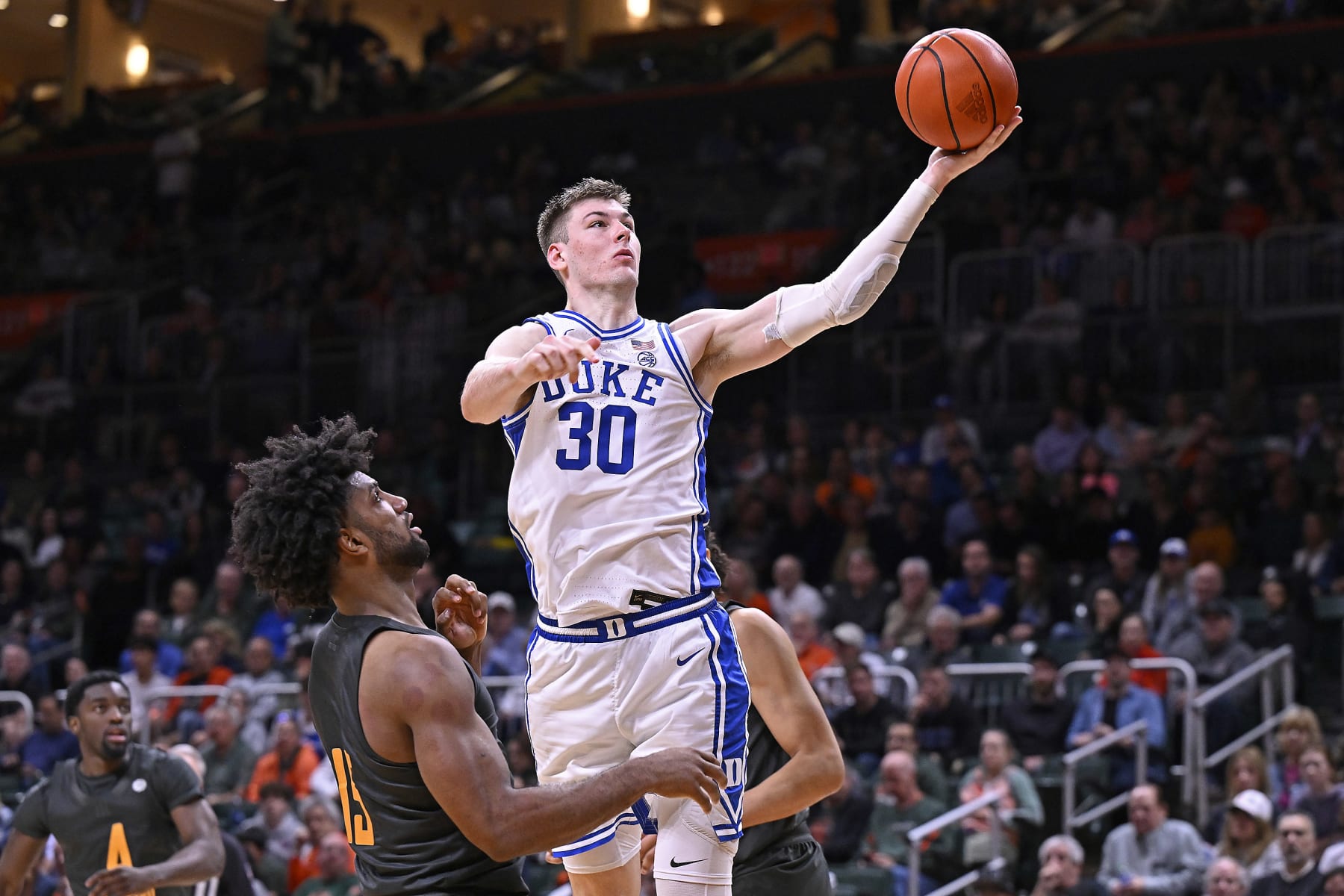 CORAL GABLES, FL - FEBRUARY 21: Duke center Kyle Filipowski (30) puts up a basket while defended by Miami forward Norchad Omier (15) in the second half as the Miami Hurricanes faced the Duke Blue Devils on February 21, 2024, at the Watsco Center in Coral Gables, Florida. (Photo by Samuel Lewis/Icon Sportswire via Getty Images)