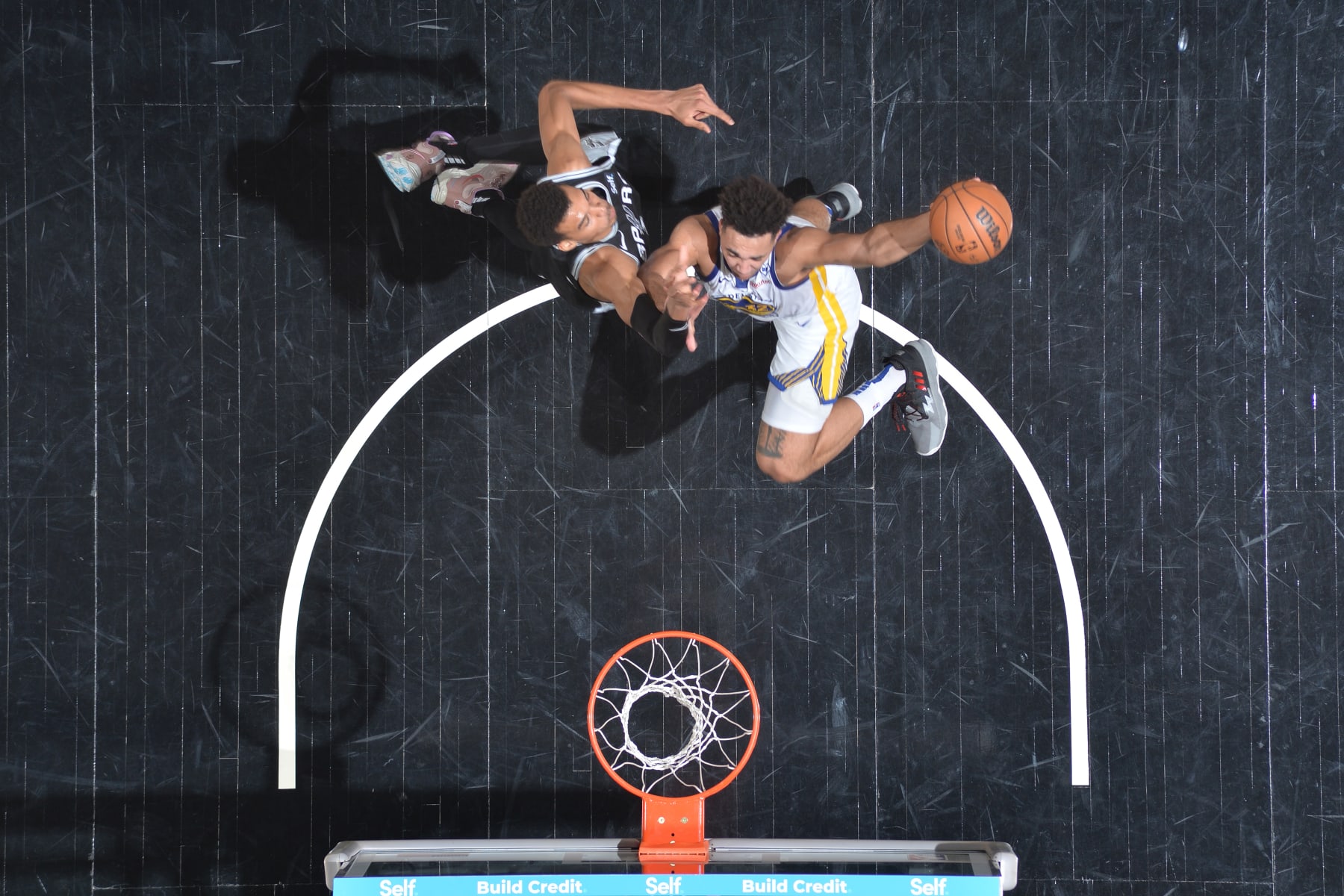 SAN ANTONIO, TX - MARCH 11:  Trayce Jackson-Davis #32 of the Golden State Warriors drives to the basket during the game as Victor Wembanyama #1 of the San Antonio Spurs plays defense on March 11, 2024 at the Frost Bank Center in San Antonio, Texas. NOTE TO USER: User expressly acknowledges and agrees that, by downloading and or using this photograph, user is consenting to the terms and conditions of the Getty Images License Agreement. Mandatory Copyright Notice: Copyright 2024 NBAE (Photos by Michael Gonzales/NBAE via Getty Images)