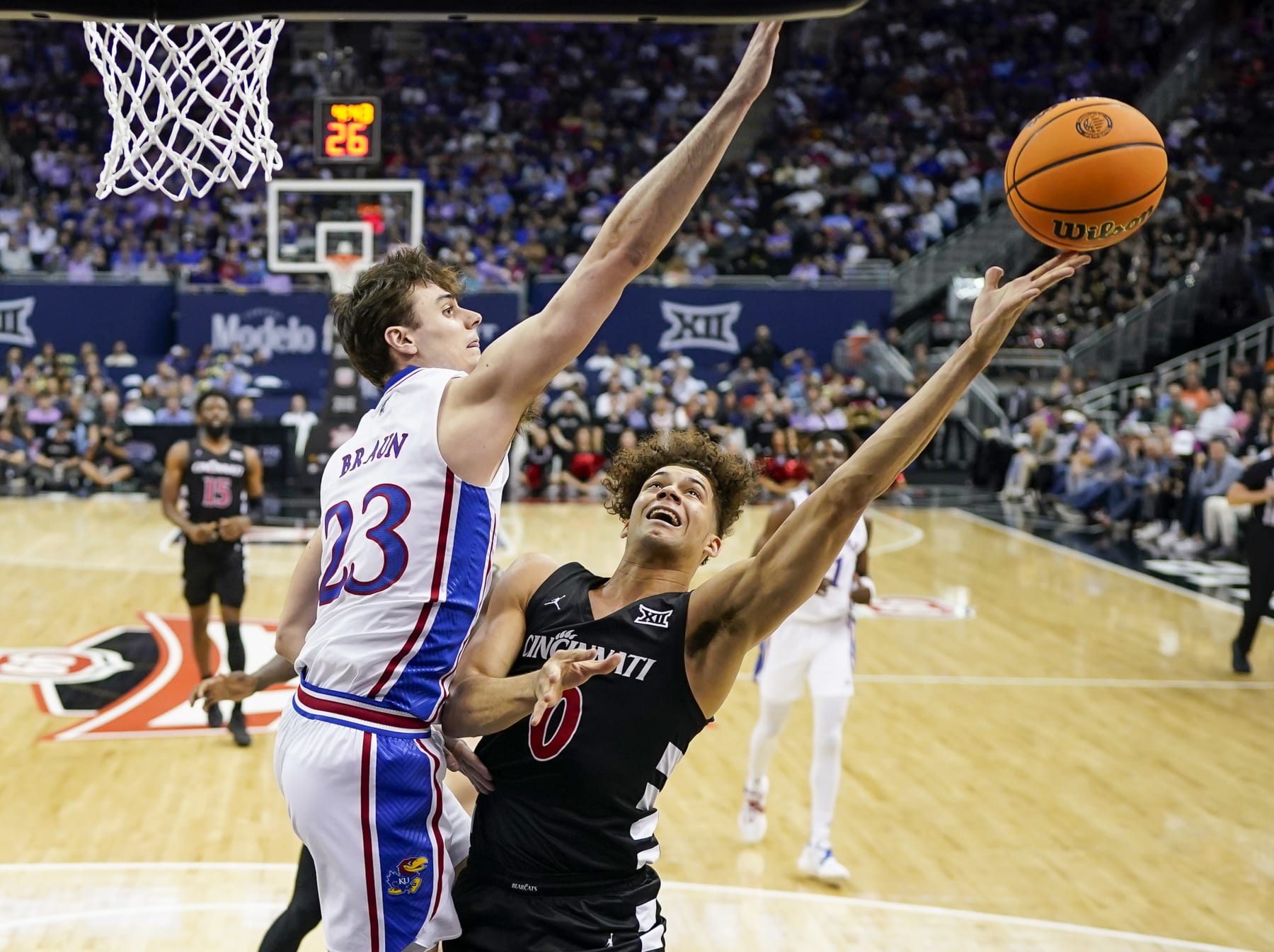 KANSAS CITY, MISSOURI - MARCH 13: Dan Skillings Jr. #0 of the Cincinnati Bearcats shoots against Parker Braun #23 of the Kansas Jayhawks during the first half in the second round of the Big 12 Men's Basketball Tournament at T-Mobile Center on March 13, 2024 in Kansas City, Missouri.  (Photo by Jay Biggerstaff/Getty Images)