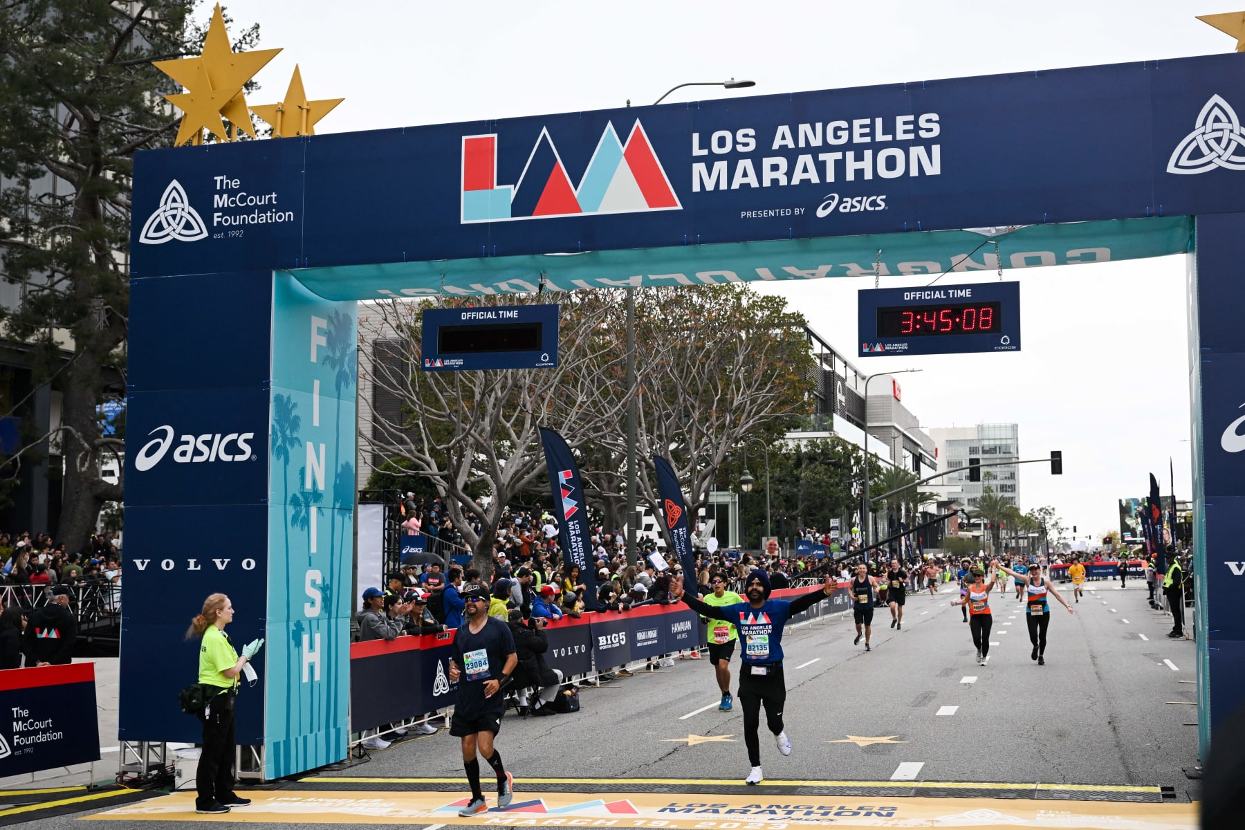 Runners cross the finish line during the 38th Los Angeles Marathon in Los Angeles, California, on March 19, 2023. (Photo by Patrick T. Fallon / AFP) (Photo by PATRICK T. FALLON/AFP via Getty Images)