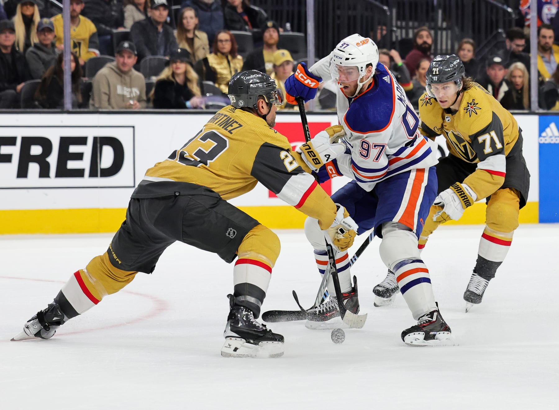 LAS VEGAS, NEVADA - FEBRUARY 06: Connor McDavid #97 of the Edmonton Oilers skates with the puck against Alec Martinez #23 and William Karlsson #71 of the Vegas Golden Knights in the third period of their game at T-Mobile Arena on February 06, 2024 in Las Vegas, Nevada. The Golden Knights defeated the Oilers 3-1. (Photo by Ethan Miller/Getty Images)
