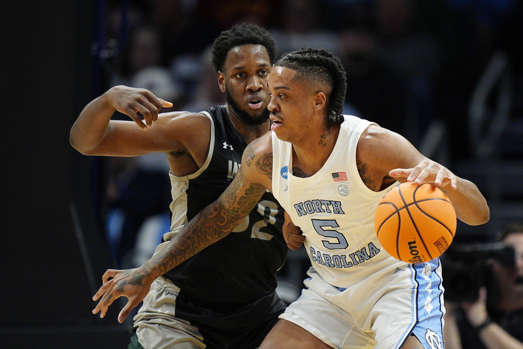 CHARLOTTE, NORTH CAROLINA - MARCH 21: Armando Bacot #5 of the North Carolina Tar Heels dribbles against Keyontae Lewis #32 of the Wagner Seahawks during the first half in the first round of the NCAA Men's Basketball Tournament at Spectrum Center on March 21, 2024 in Charlotte, North Carolina. (Photo by Jacob Kupferman/Getty Images)