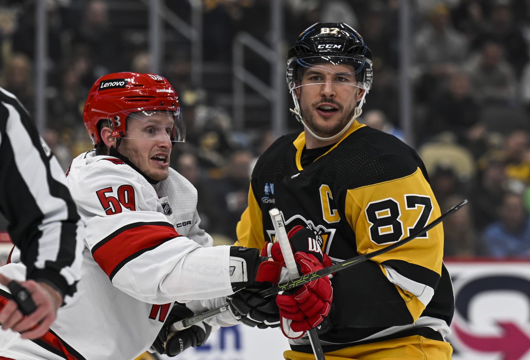PITTSBURGH, PA - MARCH 26: Pittsburgh Penguins center Sidney Crosby (87) and Carolina Hurricanes left wing Jake Guentzel (59) face-off during the first period in the NHL game between the Pittsburgh Penguins and the Carolina Hurricanes on March 26, 2024, at PPG Paints Arena in Pittsburgh, PA. (Photo by Jeanine Leech/Icon Sportswire via Getty Images)