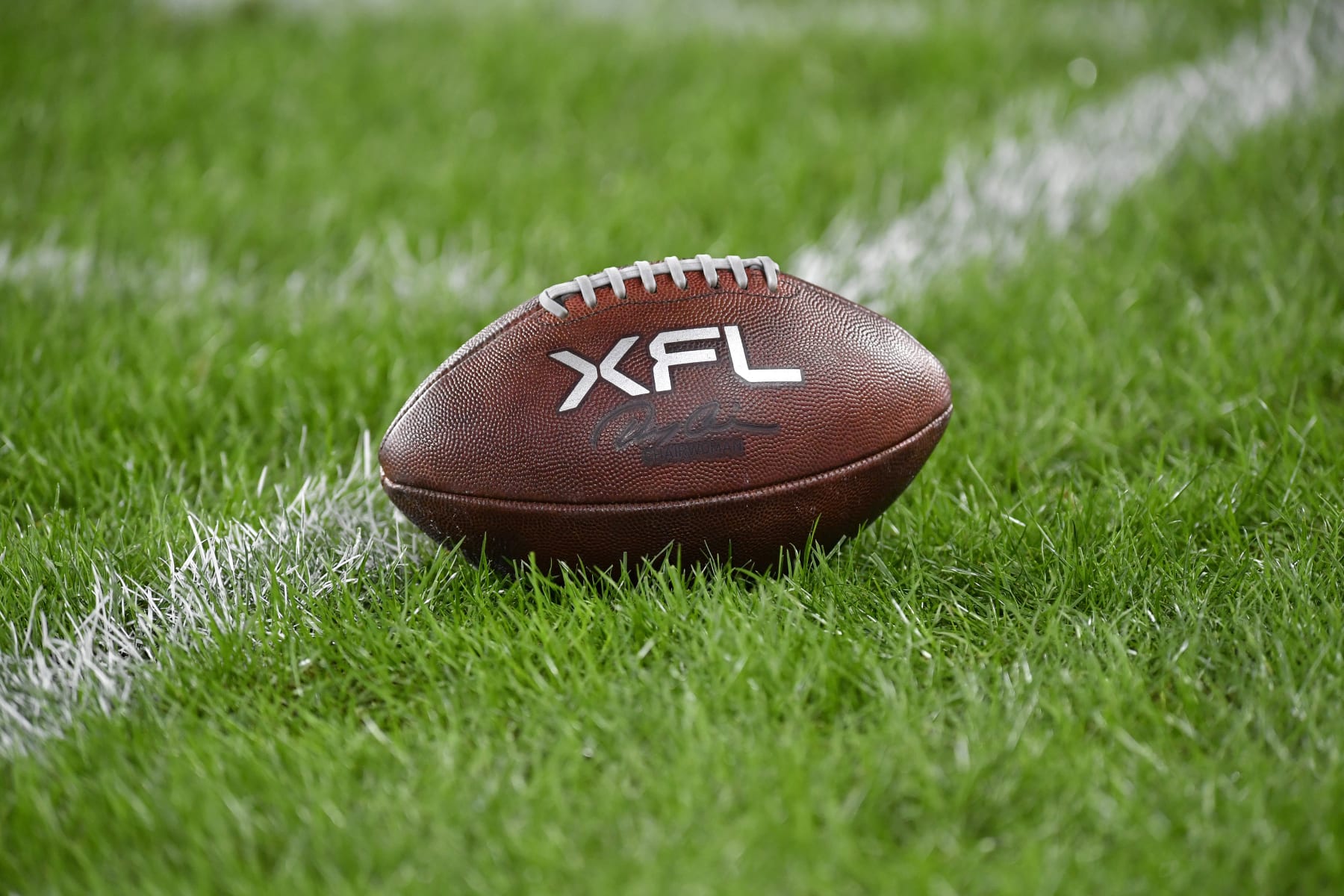 WASHINGTON, DC - FEBRUARY 19: A close up of an XFL leather game football on natural turf grass during the Seattle Sea Dragons versus D.C. Defenders XFL football game on February 19, 2023 at Audi Field in Washington, D.C.. (Photo by Randy Litzinger/Icon Sportswire via Getty Images)