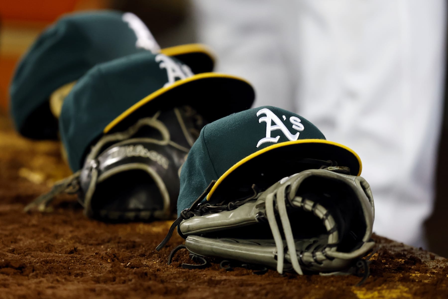 OAKLAND, CA - MARCH 28:  A detail shot of Oakland Athletics hats and gloves on the dugout steps during the game between the Cleveland Guardians and the Oakland Athletics at RingCentral Coliseum on Thursday, March 28, 2024 in Oakland, California. (Photo by Lachlan Cunningham/MLB Photos via Getty Images)