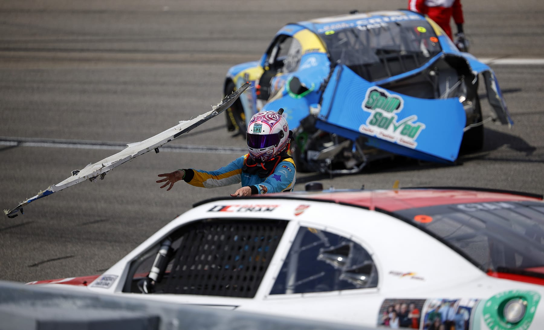 RICHMOND, VIRGINIA - MARCH 30: Joey Gase, driver of the #35 NCPC Race Against Crime Chevrolet, throws his wrecked rear bumper cover at Dawson Cram, driver of the #4 TeamJDMotorsports.com Chevrolet, after an on-track incident during the NASCAR Xfinity Series ToyotaCare 250 at Richmond Raceway on March 30, 2024 in Richmond, Virginia. (Photo by Alex Slitz/Getty Images)