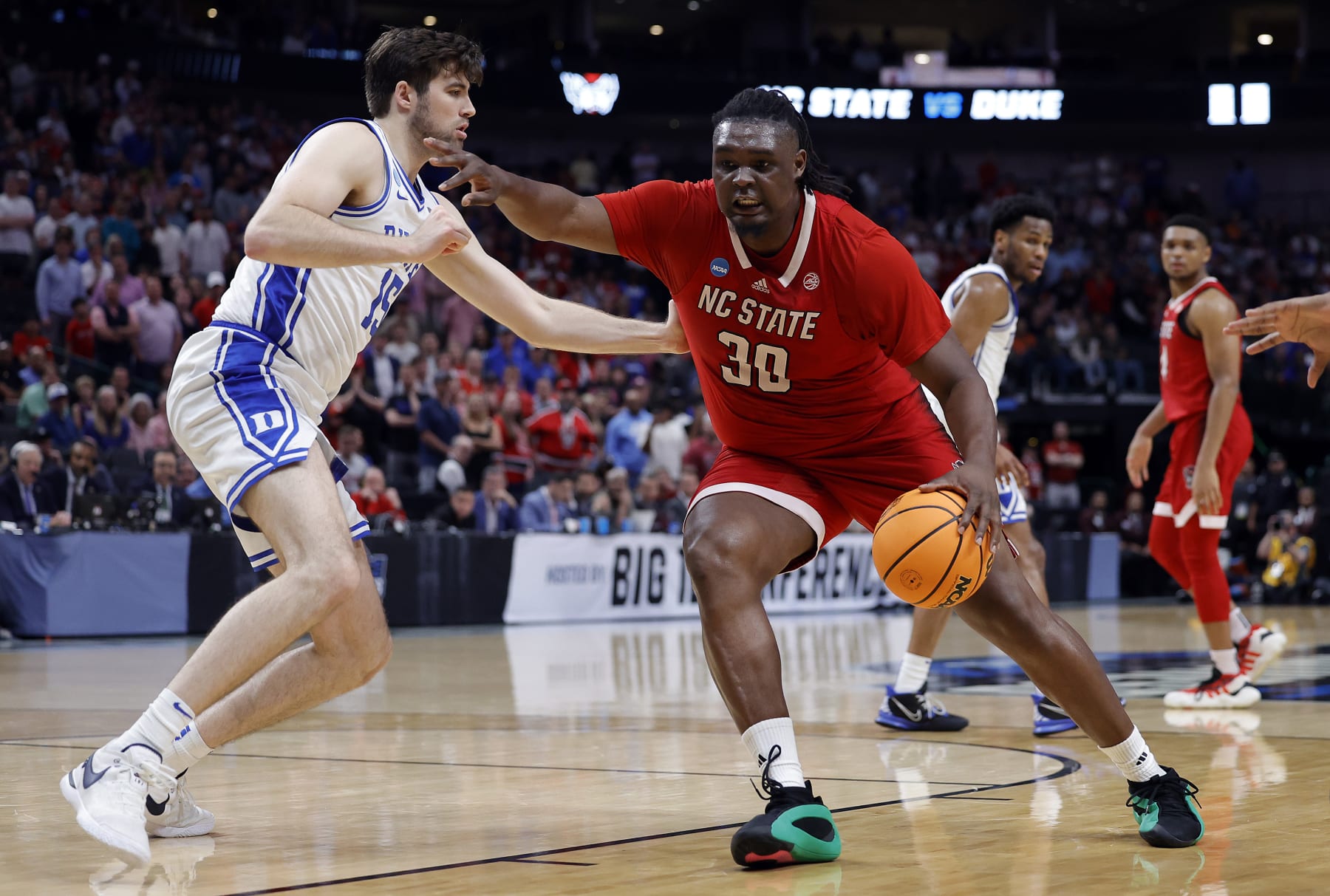 DALLAS, TEXAS - MARCH 31: DJ Burns Jr. #30 of the North Carolina State Wolfpack controls the ball as Ryan Young #15 of the Duke Blue Devils defends in the Elite 8 round of the NCAA Men's Basketball Tournament at American Airlines Center on March 31, 2024 in Dallas, Texas. (Photo by Carmen Mandato/Getty Images)