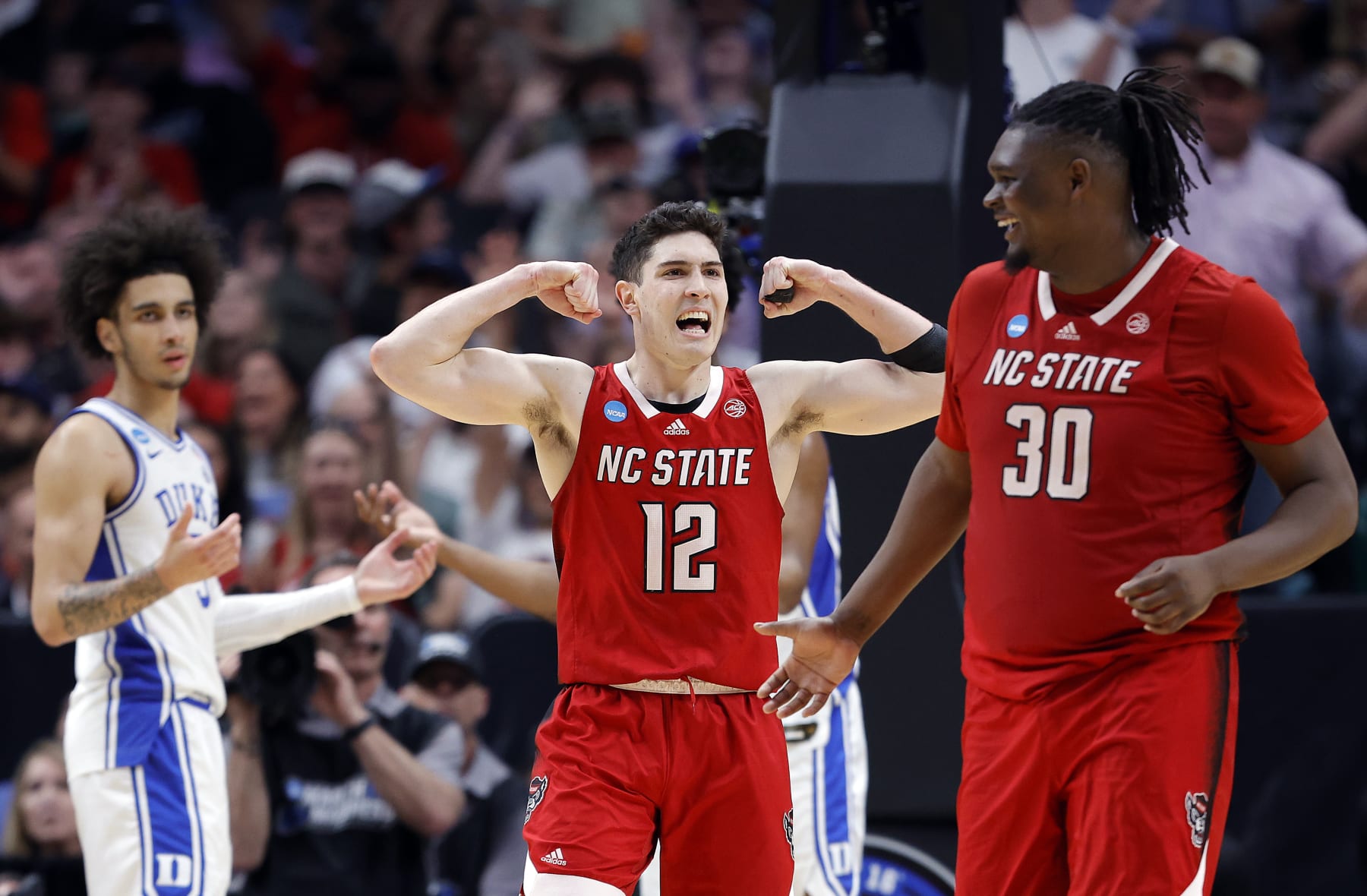 DALLAS, TEXAS - MARCH 31: Michael O'Connell #12 of the North Carolina State Wolfpack and DJ Burns Jr. #30 of the North Carolina State Wolfpack react after drawing a foul in the second half of the Elite 8 round of the NCAA Men's Basketball Tournament against the Duke Blue Devils at American Airlines Center on March 31, 2024 in Dallas, Texas. (Photo by Carmen Mandato/Getty Images)