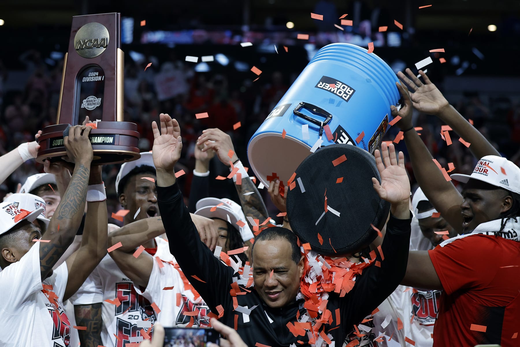 DALLAS, TEXAS - MARCH 31: Head coach Kevin Keatts of the North Carolina State Wolfpack is doused with confetti as players celebrate after the Wolfpack defeated the Duke Blue Devils to advance to the Final Four after the Elite 8 round of the NCAA Men's Basketball Tournament at American Airlines Center on March 31, 2024 in Dallas, Texas. (Photo by Carmen Mandato/Getty Images)
