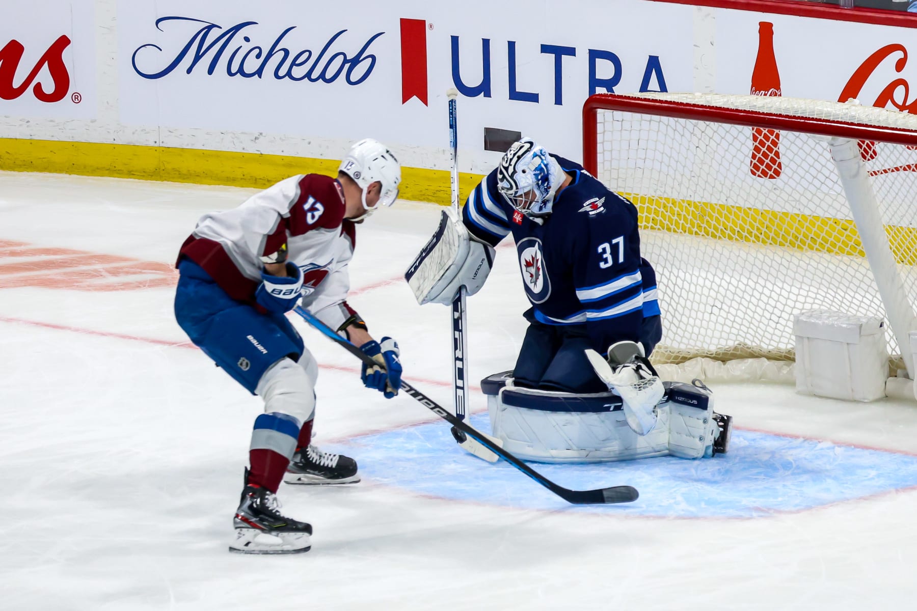 WINNIPEG, CANADA - DECEMBER 16: Goaltender Connor Hellebuyck #37 of the Winnipeg Jets makes a stick save on Valeri Nichushkin #13 of the Colorado Avalanche during first period action at the Canada Life Centre on December 16, 2023 in Winnipeg, Manitoba, Canada. (Photo by Jonathan Kozub/NHLI via Getty Images)
