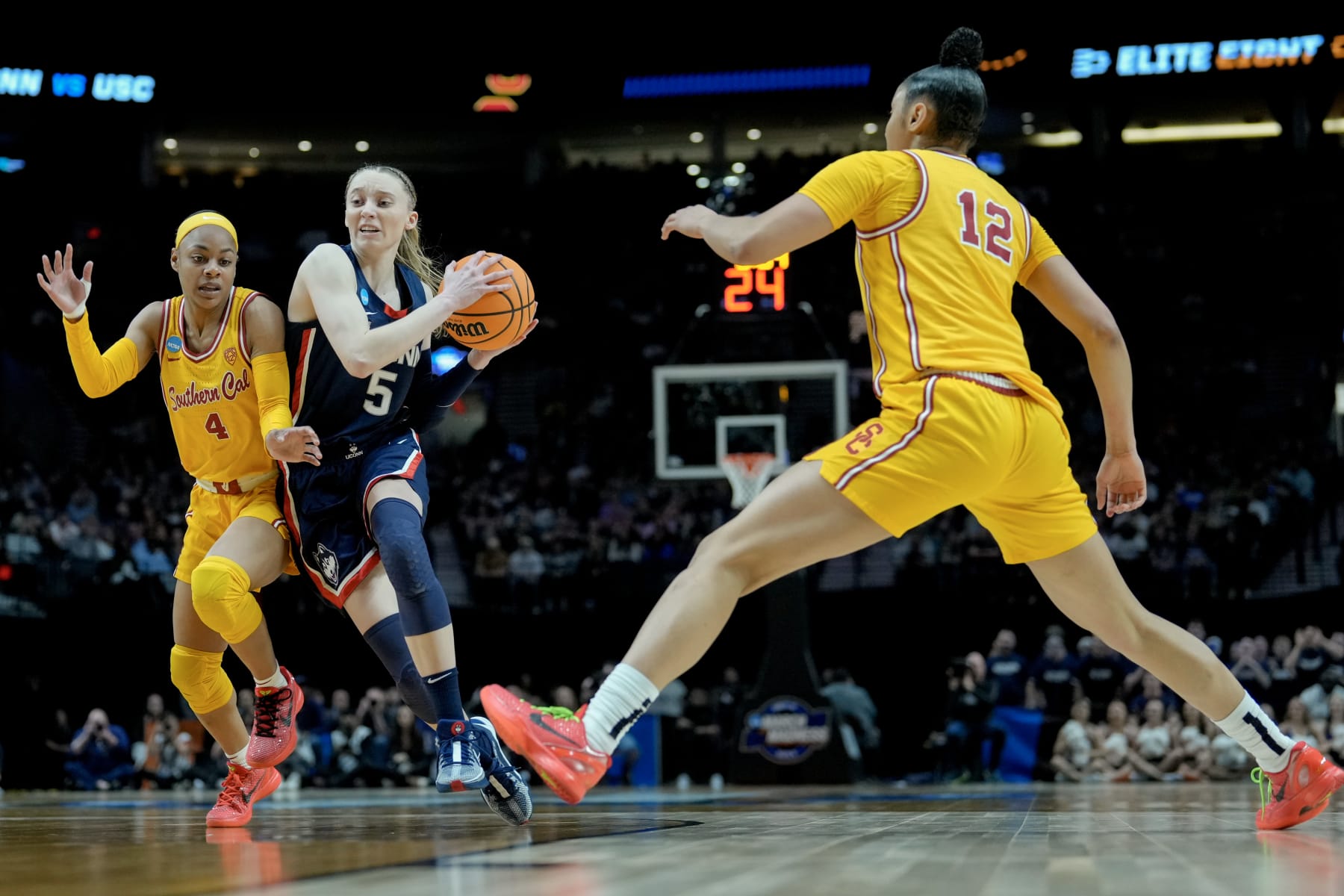 PORTLAND, OREGON - APRIL 01: Paige Bueckers #5 of the Connecticut Huskies drives past Kayla Williams #4 of the USC Trojansduring the first half in the Elite 8 round of the NCAA Women's Basketball Tournament at Moda Center on April 01, 2024 in Portland, Oregon. (Photo by Soobum Im/Getty Images)