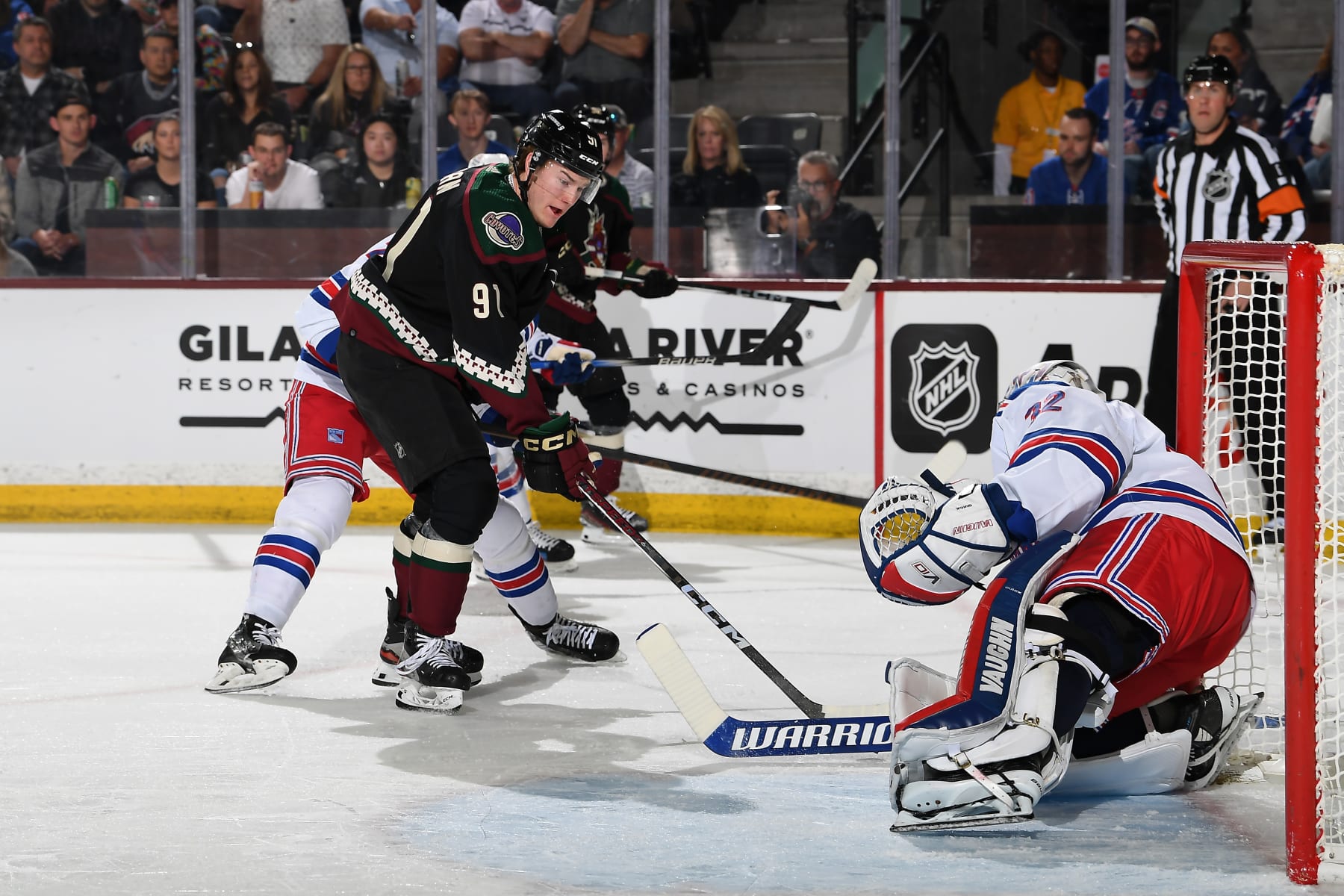 TEMPE, ARIZONA - MARCH 30: Josh Doan #91 of the Arizona Coyotes skates with the puck as Jonathan Quick #32 of the New York Rangers gets ready to make a save during the first period of the game at Mullett Arena on March 30, 2024 in Tempe, Arizona. (Photo by Norm Hall/NHLI via Getty Images)