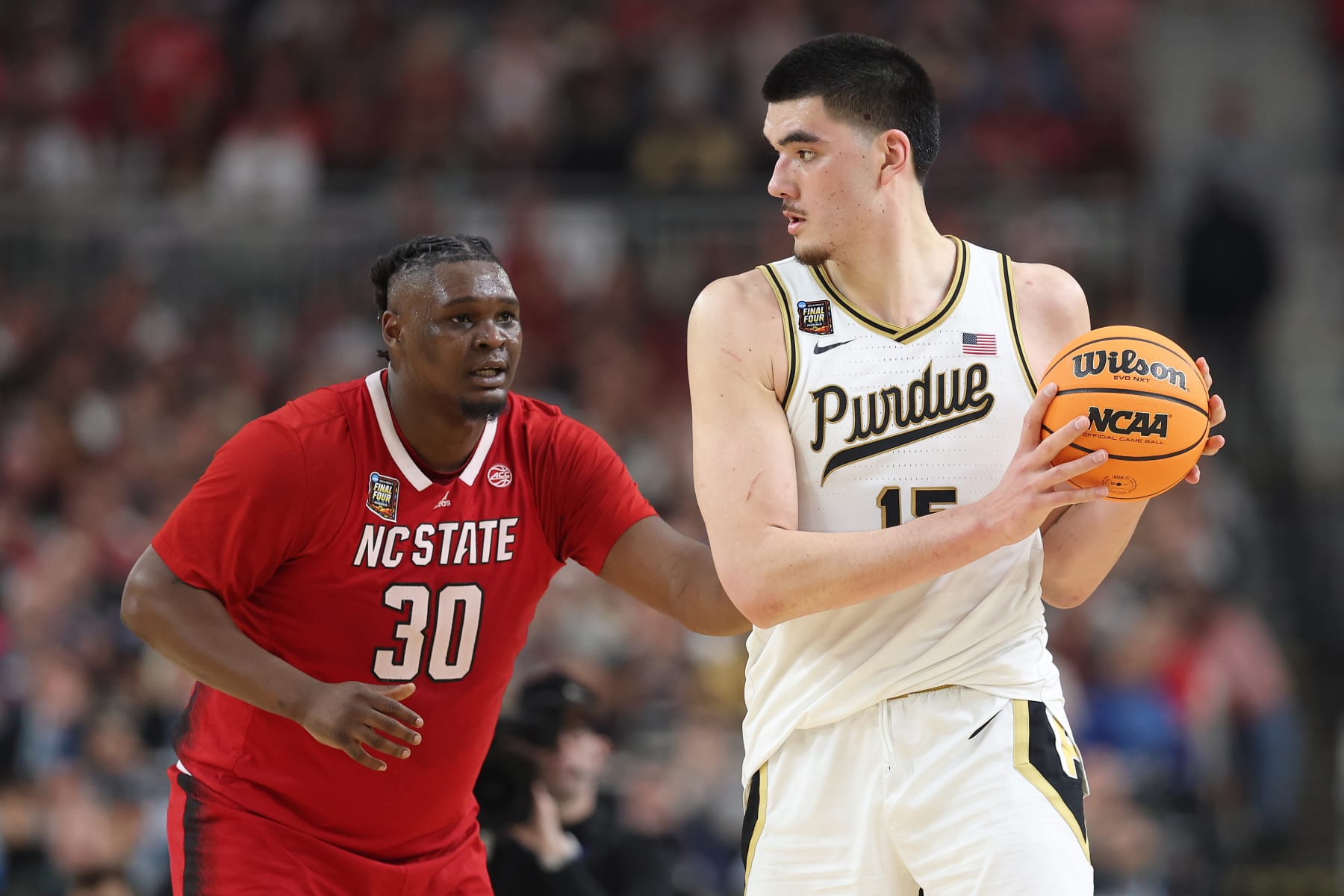 GLENDALE, ARIZONA - APRIL 06: Zach Edey #15 of the Purdue Boilermakers handles the ball while being guarded by DJ Burns Jr. #30 of the North Carolina State Wolfpack in the second half in the NCAA Men's Basketball Tournament Final Four semifinal game at State Farm Stadium on April 06, 2024 in Glendale, Arizona. (Photo by Christian Petersen/Getty Images)