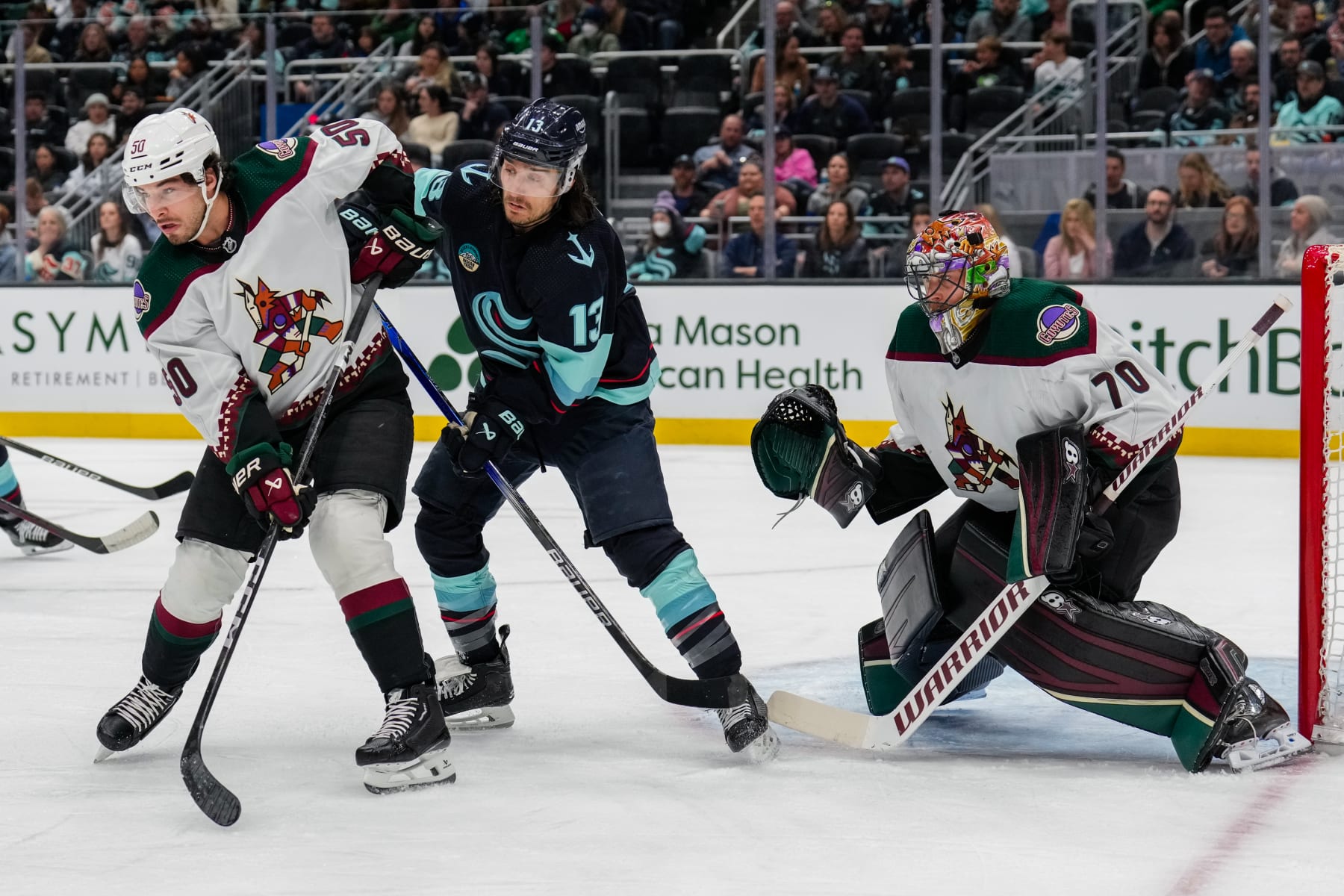 SEATTLE, WASHINGTON - APRIL 09: Sean Durzi #50 of the Arizona Coyotes and Brandon Tanev #13 of the Seattle Kraken battle for position during the first period of a game against the OPPONENT at Climate Pledge Arena on April 9, 2024 in Seattle, Washington. (Photo by Christopher Mast/NHLI via Getty Images)