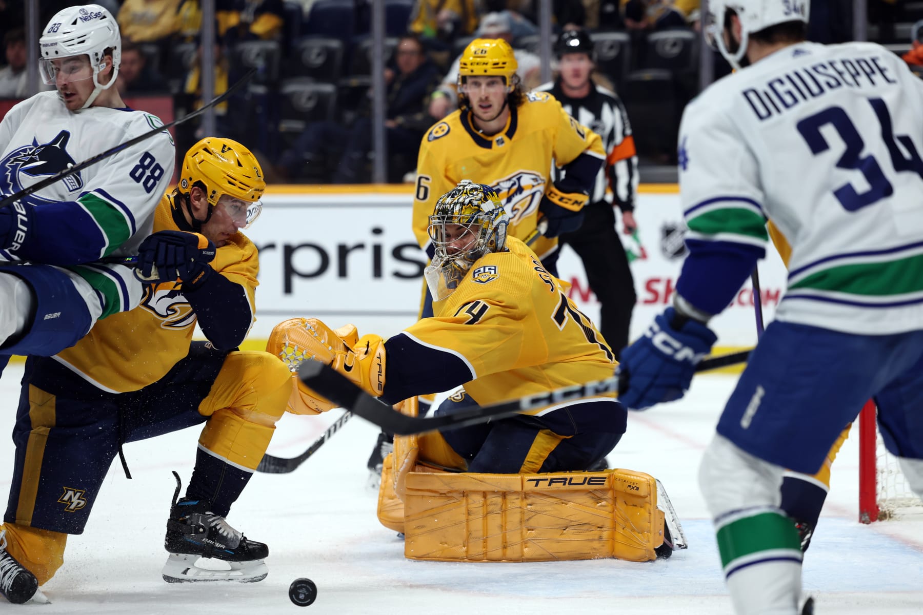 NASHVILLE, TENNESSEE - DECEMBER 19: Juuse Saros #74 of the Nashville Predators defends the net against the Vancouver Canucks with Luke Schenn #2 of the Nashville Predators and Nils Aman #88 of the Vancouver Canucks nearby at Bridgestone Arena on December 19, 2023 in Nashville, Tennessee. The Vancouver Canucks won the game 5-2. (Photo by Donald Page/Getty Images)