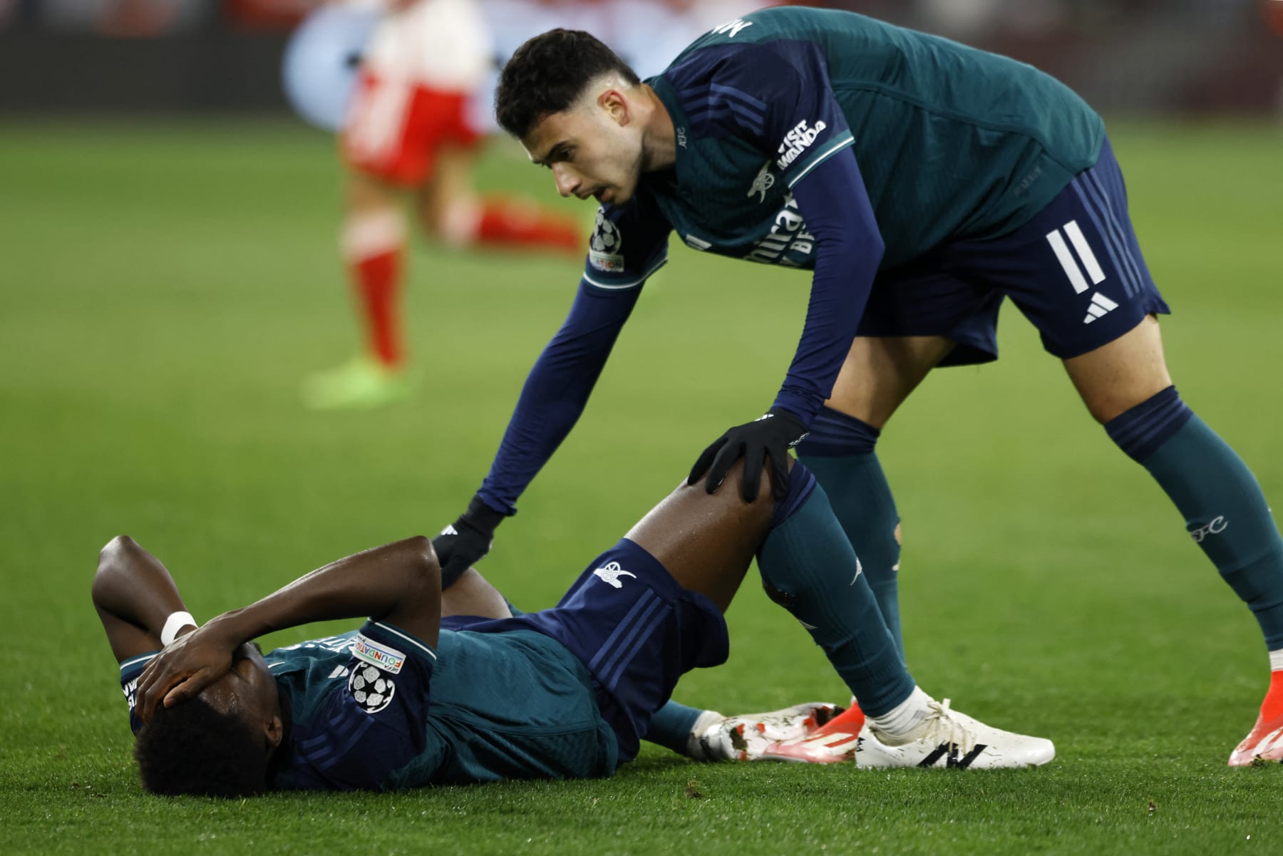 Arsenal's Brazilian midfielder #11 Gabriel Martinelli (R) reacts as Arsenal's English midfielder #07 Bukayo Saka lies on the pitch after having been hit with the ball on the head during the UEFA Champions League quarter-final second leg football match between FC Bayern Munich and Arsenal FC in Munich, southern Germany on April 17, 2024. (Photo by Michaela STACHE / AFP) (Photo by MICHAELA STACHE/AFP via Getty Images)
