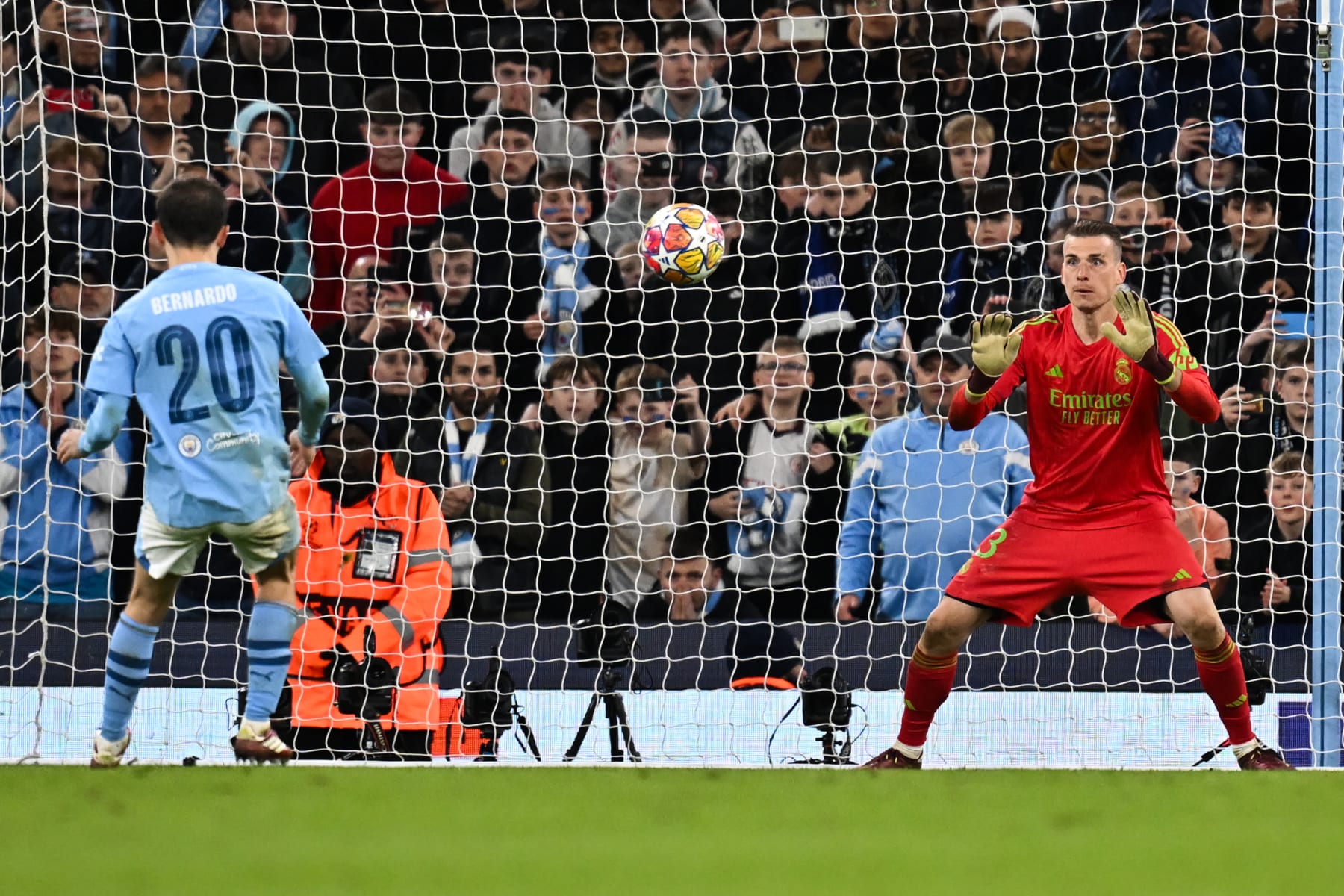 Real Madrid's Ukrainian goalkeeper #13 Andriy Lunin saves the ball shot by Manchester City's Portuguese midfielder #20 Bernardo Silva during the penalty shootout during the UEFA Champions League quarter-final second-leg football match between Manchester City and Real Madrid, at the Etihad Stadium, in Manchester, north-west England, on April 17, 2024. (Photo by Paul ELLIS / AFP) (Photo by PAUL ELLIS/AFP via Getty Images)