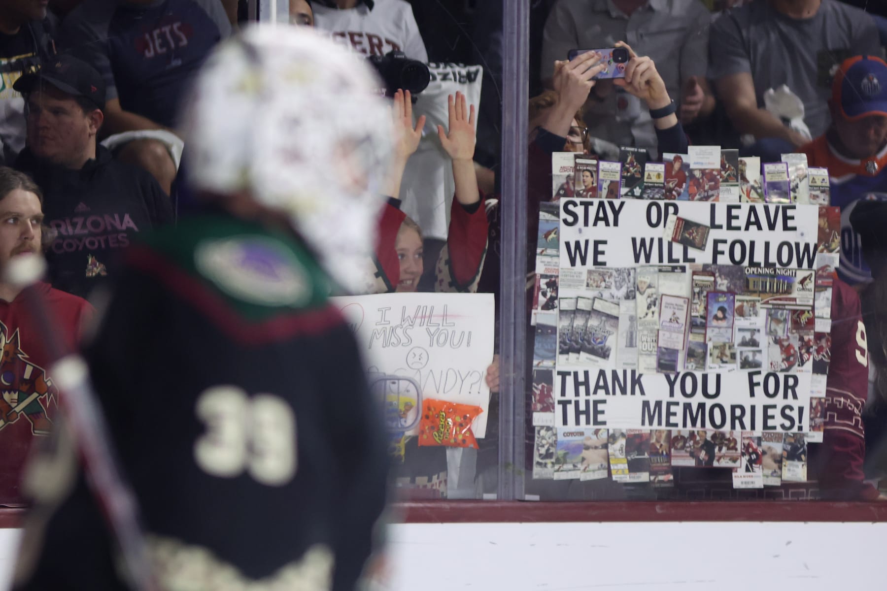 TEMPE, ARIZONA - APRIL 17: Fans hold up signs before the NHL game between the Edmonton Oilers and the Arizona Coyotes at Mullett Arena on April 17, 2024 in Tempe, Arizona. Tonight's game likely marks the end of 28 years for the franchise playing in the NHL's smallest arena with an anticpated move to Utah with the team's expected sale to the NBA's Utah Jazz owner Ryan Smith. (Photo by Christian Petersen/Getty Images)
