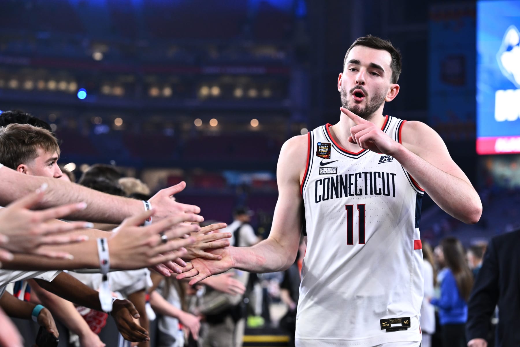 GLENDALE, ARIZONA - APRIL 06: Alex Karaban #11 of the Connecticut Huskies high fives fans after defeating the Alabama Crimson Tide in the NCAA Men’s Basketball Tournament Final Four semifinal game at State Farm Stadium on April 06, 2024 in Glendale, Arizona. (Photo by Brett Wilhelm/NCAA Photos via Getty Images)