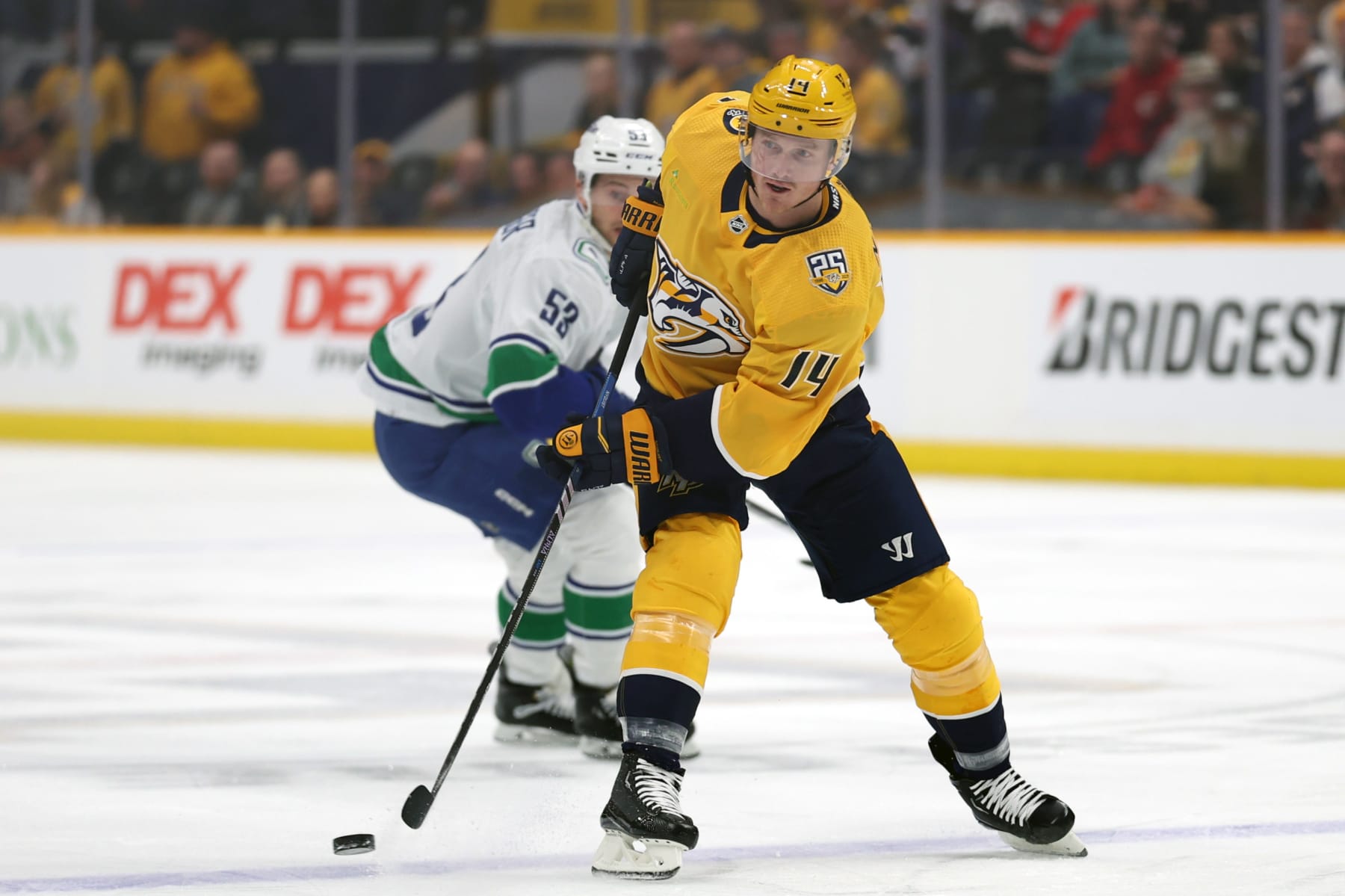 NASHVILLE, TENNESSEE - DECEMBER 19: Gustav Nyquist #14 of the Nashville Predators looks to pass the puck with Teddy Blueger #53 of the Vancouver Canucks defending at Bridgestone Arena on December 19, 2023 in Nashville, Tennessee. The Vancouver Canucks won the game 5-2. (Photo by Donald Page/Getty Images)