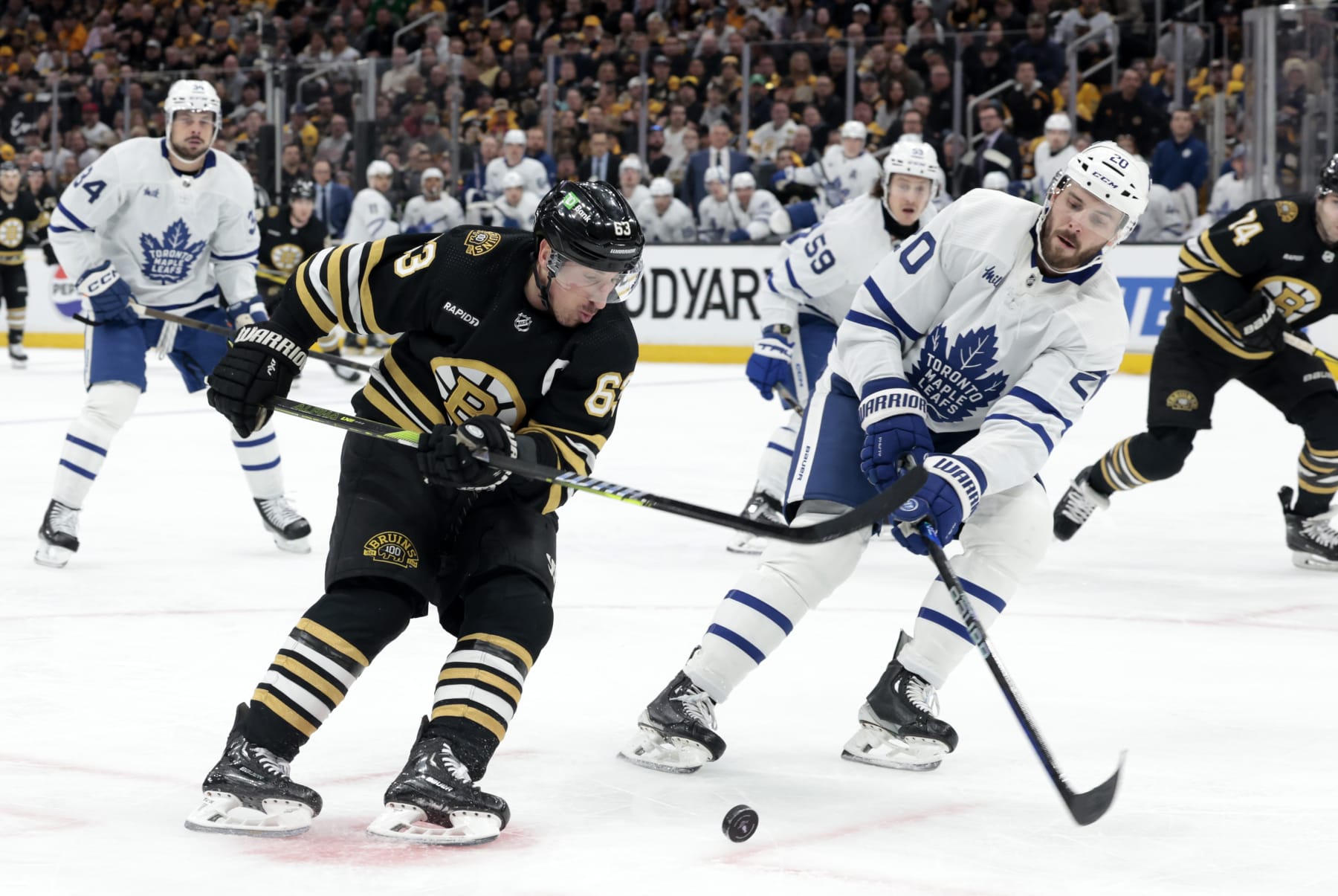 BOSTON, MA - APRIL 22: Boston Bruins left wing Brad Marchand (63) drives past Toronto Maple Leafs defenseman Joel Edmundson (20) during Game 2 of the Eastern Conference First Round playoffs between the Boston Bruins and the Toronto Maple Leafs on April 22, 2024, at TD Garden in Boston, Massachusetts. (Photo by Fred Kfoury III/Icon Sportswire via Getty Images)