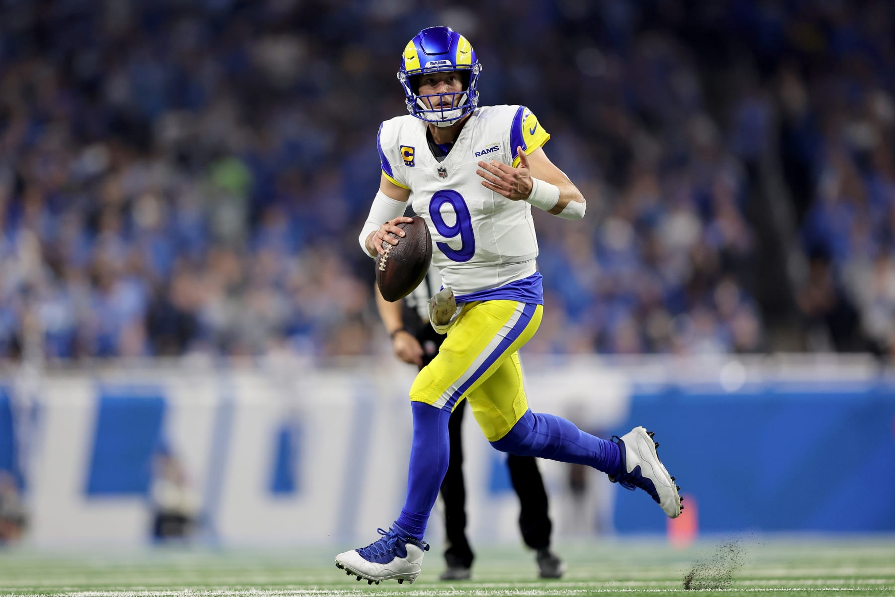 DETROIT, MICHIGAN - JANUARY 14: Matthew Stafford #9 of the Los Angeles Rams scrambles with the ball during the third quarter against the Detroit Lions in the NFC Wild Card Playoffs at Ford Field on January 14, 2024 in Detroit, Michigan. (Photo by Rey Del Rio/Getty Images)
