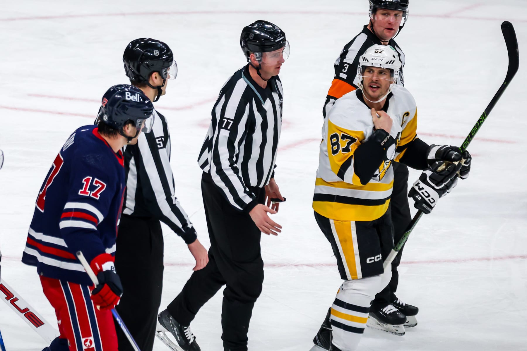 WINNIPEG, CANADA - FEBRUARY 10: Linesmen keep Adam Lowry #17 of the Winnipeg Jets and Sidney Crosby #87 of the Pittsburgh Penguins separated following a second period scrum at the Canada Life Centre on February 10, 2024 in Winnipeg, Manitoba, Canada. (Photo by Jonathan Kozub/NHLI via Getty Images)