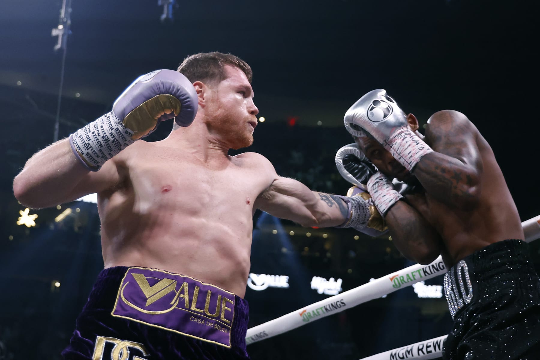 LAS VEGAS, NEVADA - SEPTEMBER 30: Saul "Canelo" Alvarez of Mexico (purple/gold trunks) trades punches with Jermell Charlo (black trunks) during their super middleweight title fight at T-Mobile Arena on September 30, 2023 in Las Vegas, Nevada. (Photo by Sarah Stier/Getty Images)