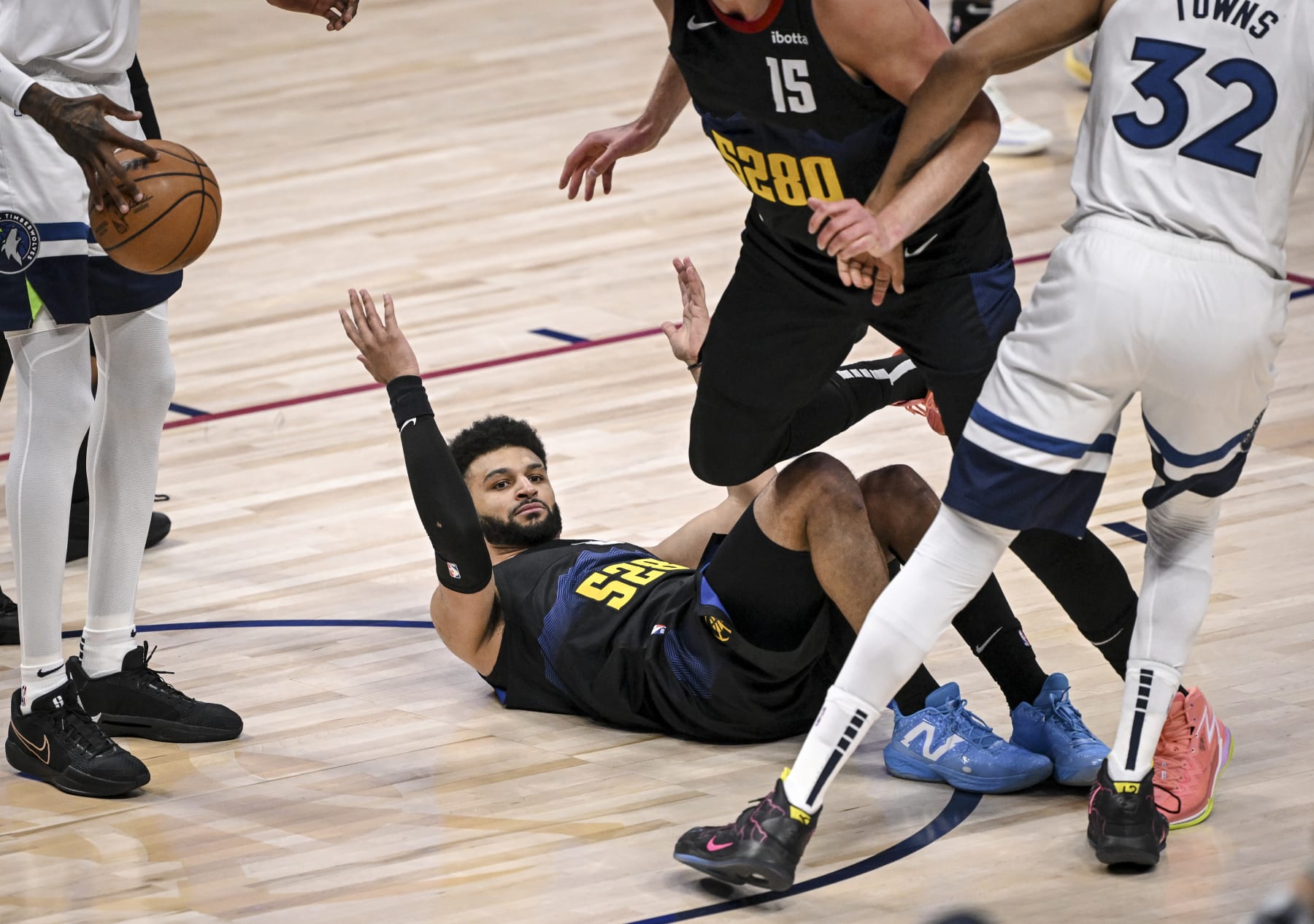 DENVER, CO - MAY 6: Jamal Murray (27) of the Denver Nuggets lies on the floor expecting a charging call against Karl-Anthony Towns (32) of the Minnesota Timberwolves during the first quarter at Ball Arena in Denver on Monday, May 6, 2024. The call would not come resulting in an eruption by Nuggets head coach Michael Malone. (Photo by AAron Ontiveroz/The Denver Post)