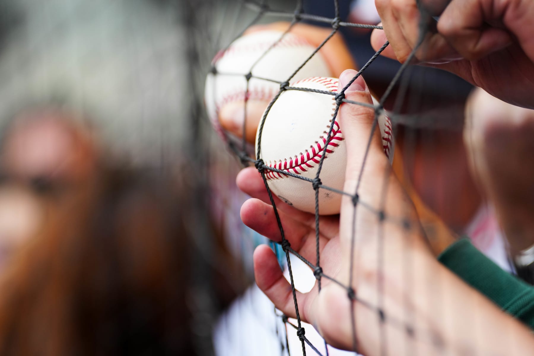 MEXICO CITY, MEXICO - APRIL 27:  Fans hold baseballs up to netting to try to get autographs during batting practice prior to a 2024 Mexico City Series game between the Houston Astros and the Colorado Rockies at Alfredo Harp Helú Stadium on Saturday, April 27, 2024 in Mexico City, Mexico. (Photo by Mary DeCicco/MLB Photos via Getty Images)