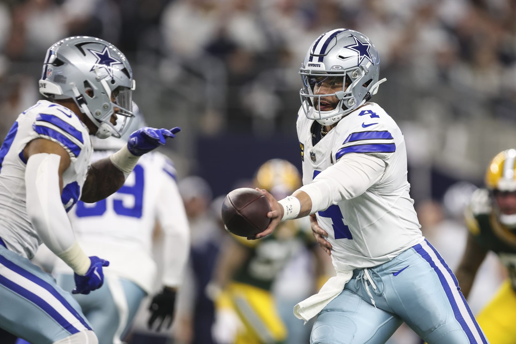 ARLINGTON, TX - JANUARY 14: Dak Prescott #4 of the Dallas Cowboys hands the ball off during an NFL wild-card playoff football game against the Green Bay Packers at AT&T Stadium on January 14, 2024 in Arlington, Texas. (Photo by Perry Knotts/Getty Images)