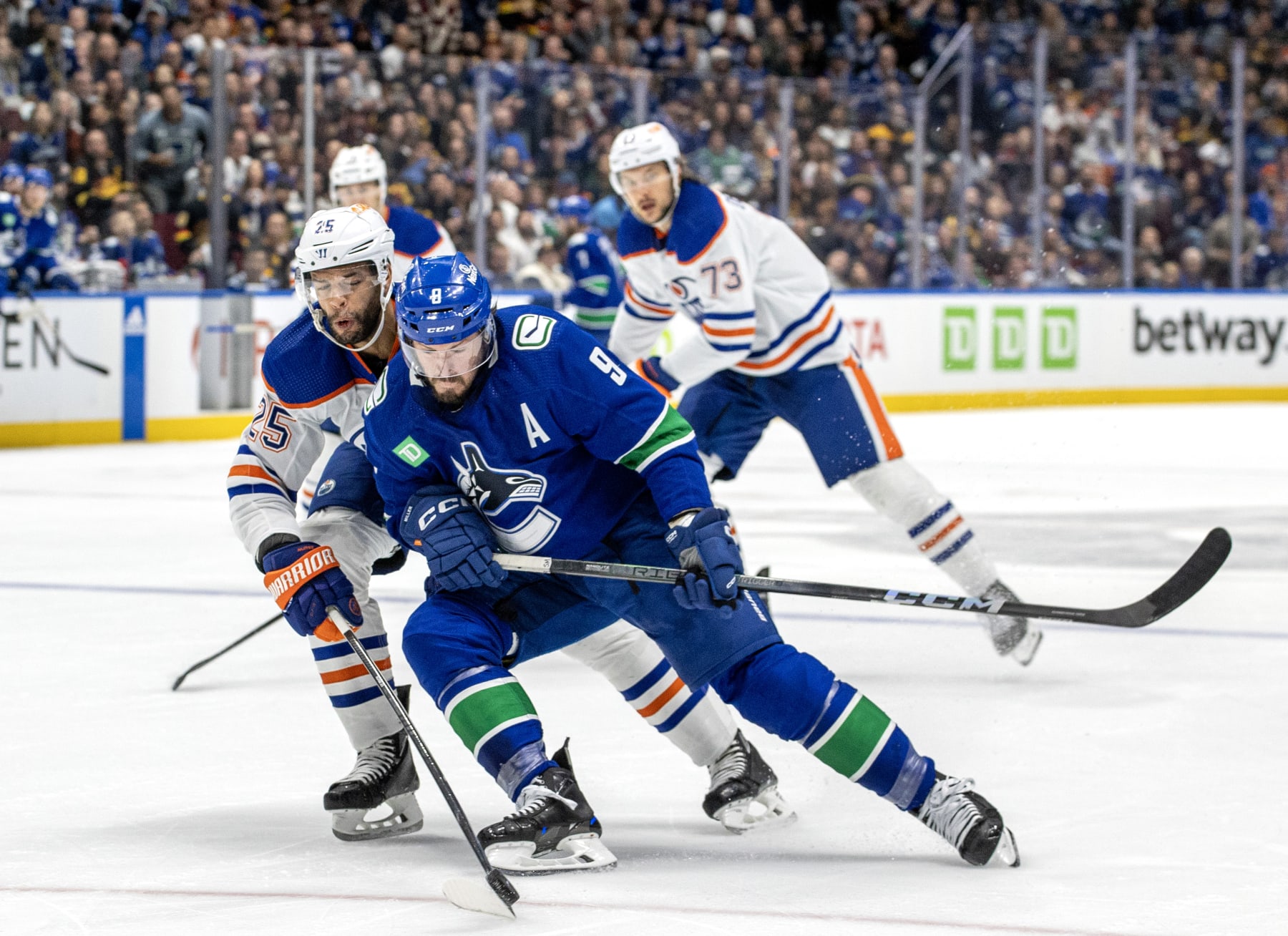 VANCOUVER, CANADA - MAY 16: J.T. Miller #9 of the Vancouver Canucks and Darnell Nurse #25 of the Edmonton Oilers battle for the puck during the first period in Game Five of the Second Round of the 2024 Stanley Cup Playoffs at Rogers Arena on May 16, 2024 in Vancouver, British Columbia, Canada.  (Photo by Jeff Vinnick/NHLI via Getty Images)