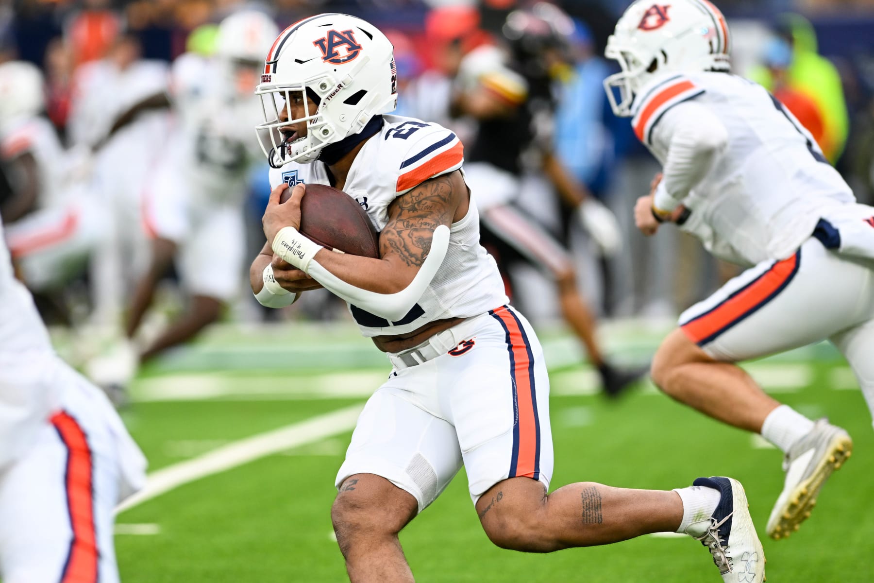 NASHVILLE, TENNESSEE - DECEMBER 30: Brian Battie #21 of the Auburn Tigers runs the ball against the Maryland Terrapins in the first half of the TransPerfect Music City Bowl at Nissan Stadium on December 30, 2023 in Nashville, Tennessee. (Photo by Carly Mackler/Getty Images)