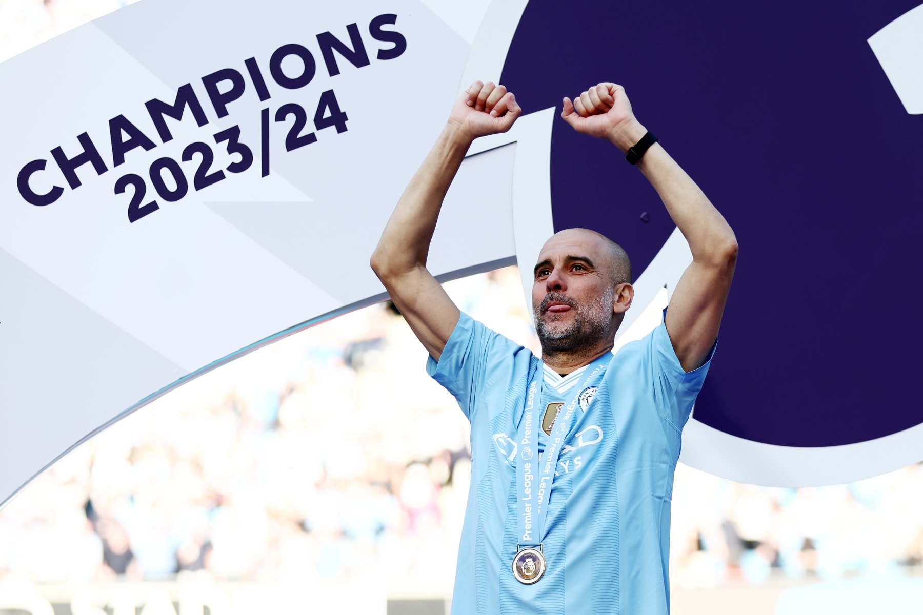 MANCHESTER, ENGLAND - MAY 19: Pep Guardiola, Manager of Manchester City, celebrates with his Winners Medal as he acknowledges the fans from the Winners Podium after the Premier League match between Manchester City and West Ham United at Etihad Stadium on May 19, 2024 in Manchester, England. (Photo by Naomi Baker/Getty Images)