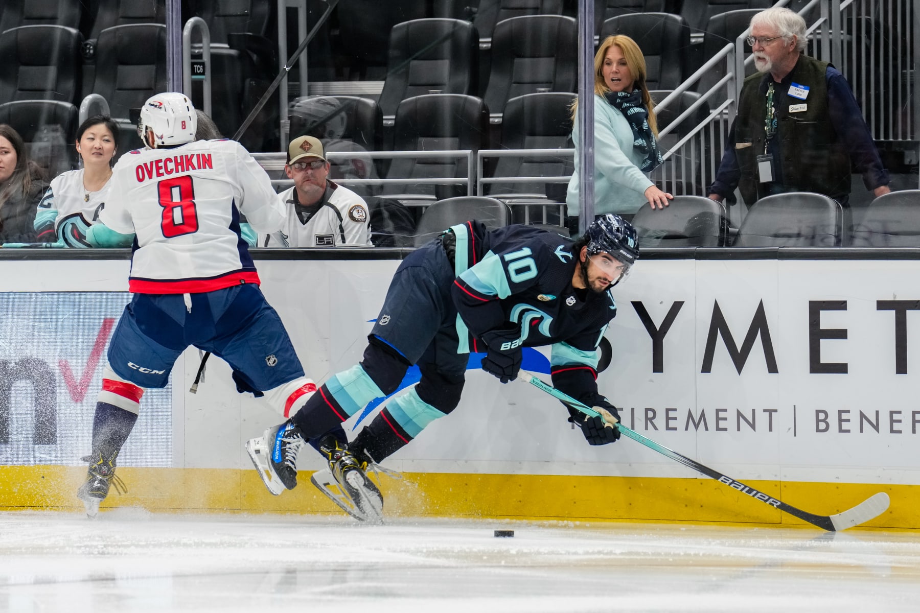 SEATTLE, WASHINGTON - MARCH 14: Matty Beniers #10 of the Seattle Kraken reacts to a check from Alex Ovechkin #8 of the Washington Capitals during the second period of a game at Climate Pledge Arena on March 14, 2024 in Seattle, Washington. (Photo by Christopher Mast/NHLI via Getty Images)