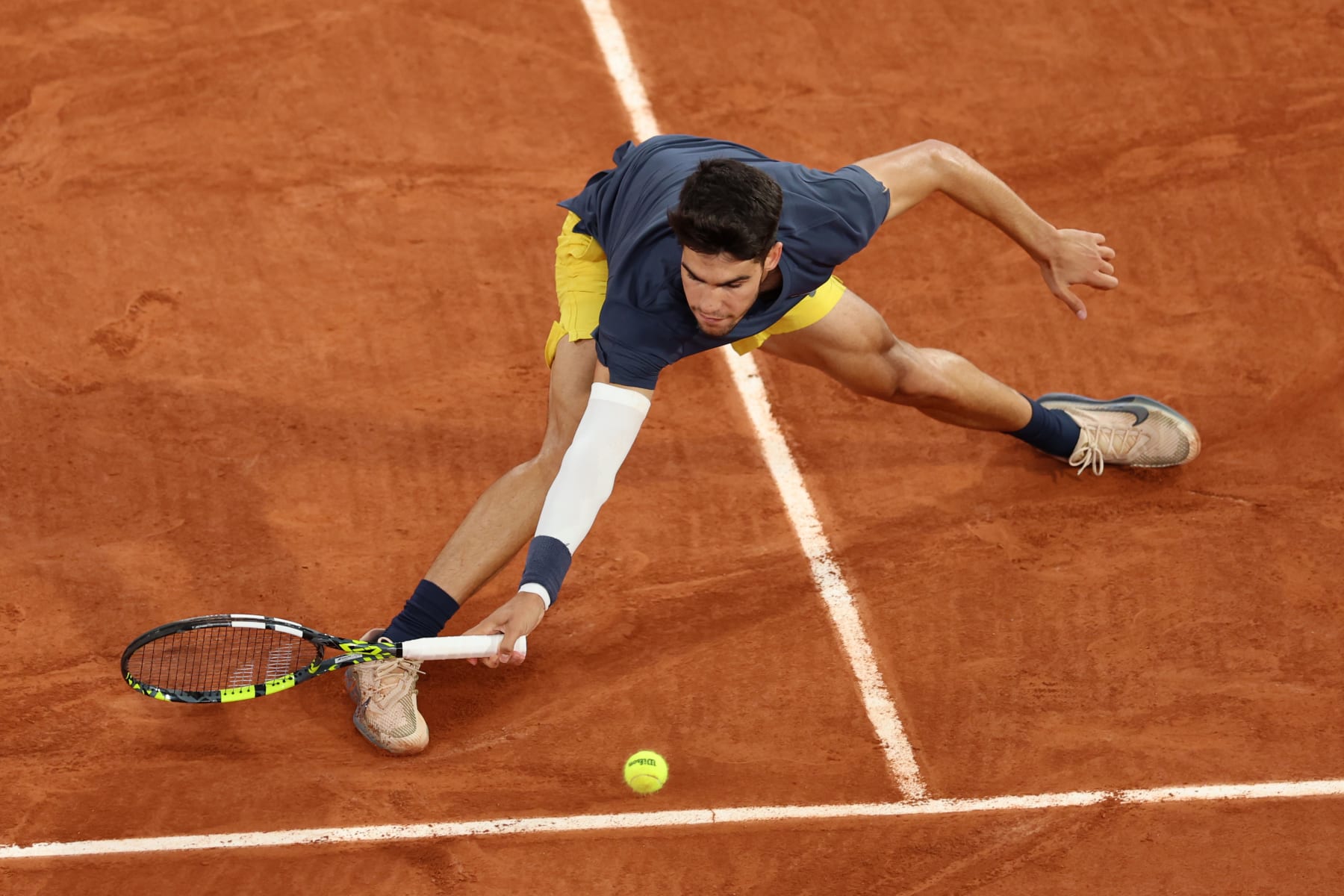 PARIS, FRANCE - MAY 29: Carlos Alcaraz of Spain stretches for a forehand against Jesper De Jong of the Netherlands in the Men's Singles second round match during Day Four of the 2024 French Open at Roland Garros on May 29, 2024 in Paris, France. (Photo by Clive Brunskill/Getty Images)