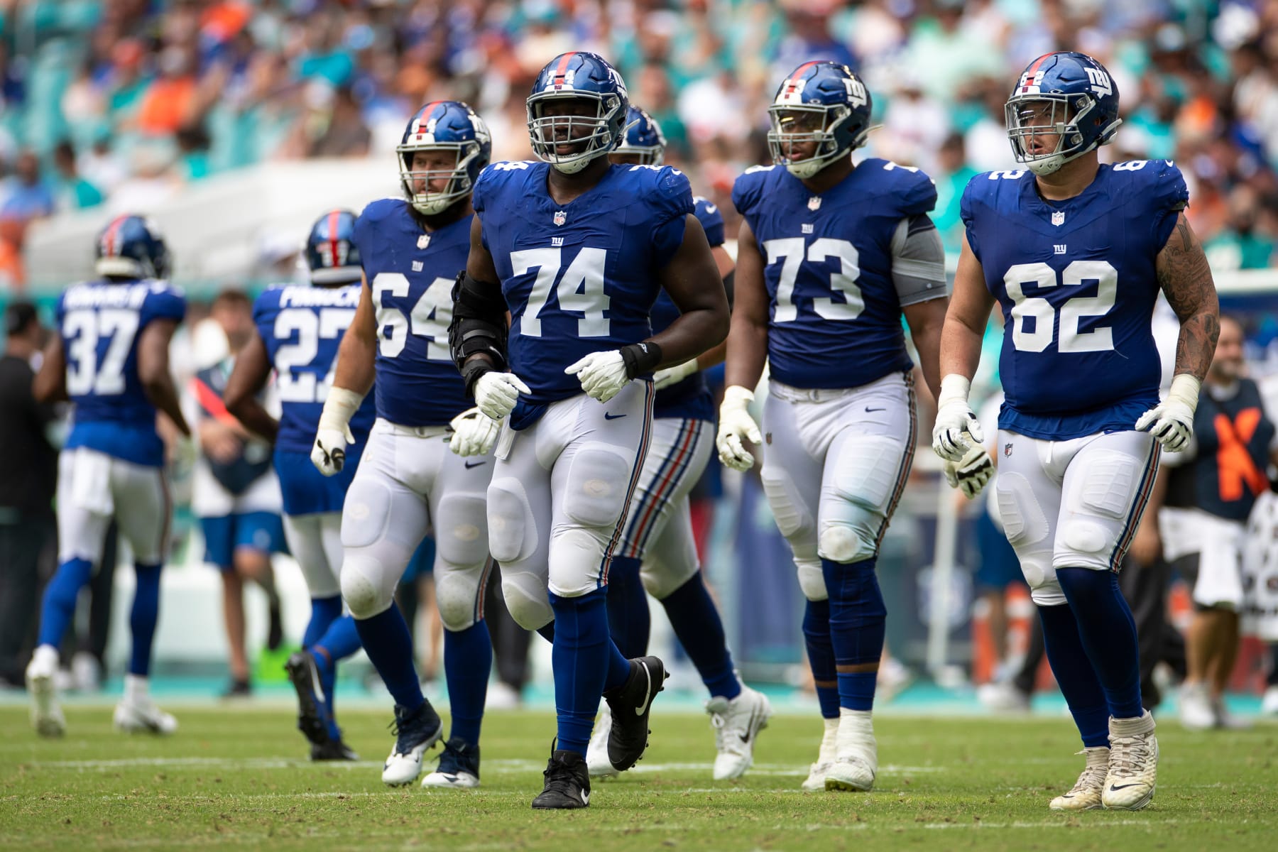MIAMI GARDENS, FLORIDA - OCTOBER 8: Matt Peart #74, Jalen Mayfield #62, Evan Neal #73, and Mark Glowinski #64 of the New York Giants walk on the field against the Miami Dolphins in the second half at Hard Rock Stadium on October 8, 2023 in Miami Gardens, Florida. (Photo by Brandon Sloter/Image Of Sport/Getty Images)