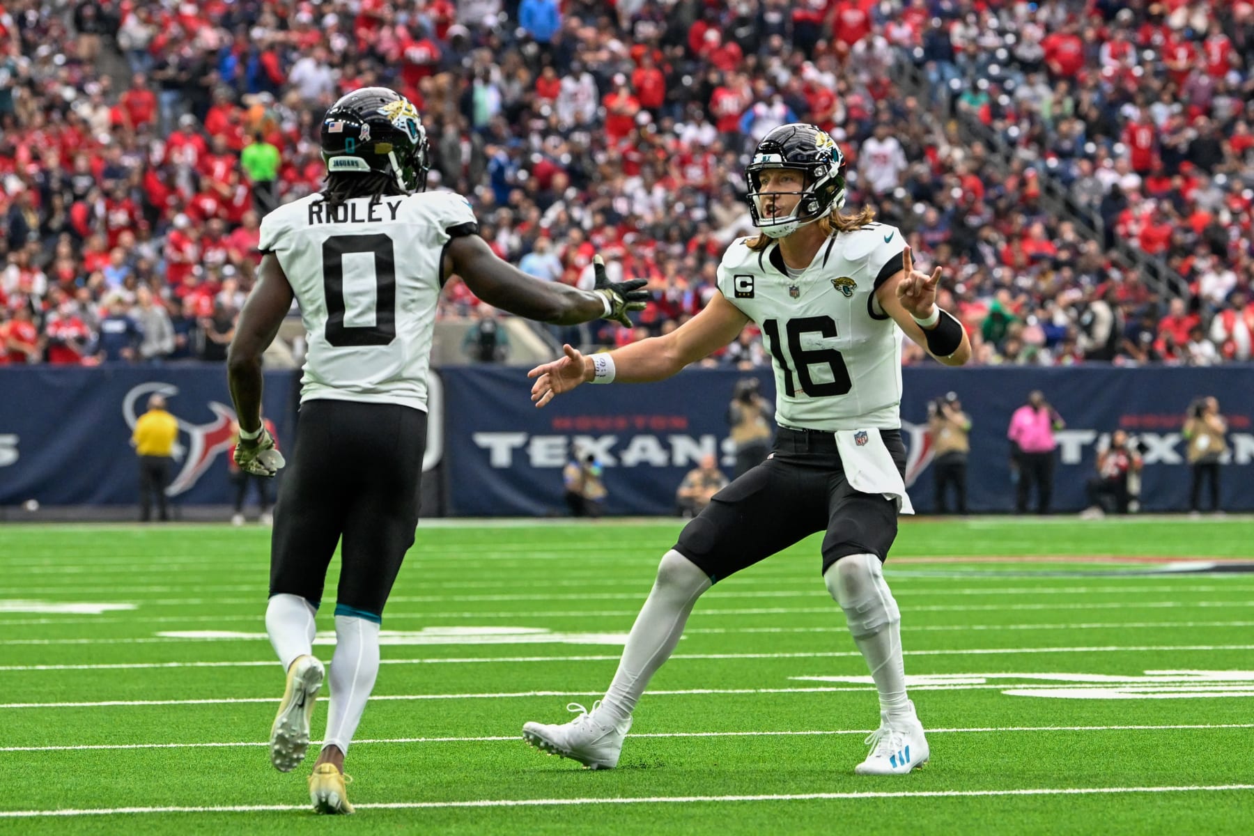 HOUSTON, TX - NOVEMBER 26: Jacksonville Jaguars wide receiver Calvin Ridley (0) and Jacksonville Jaguars quarterback Trevor Lawrence (16) celebrate their second half touchdown pass and reception during the football game between the Jacksonville Jaguars and Houston Texans at NRG Stadium on November 26, 2023, in Houston, Texas. (Photo by Ken Murray/Icon Sportswire via Getty Images)