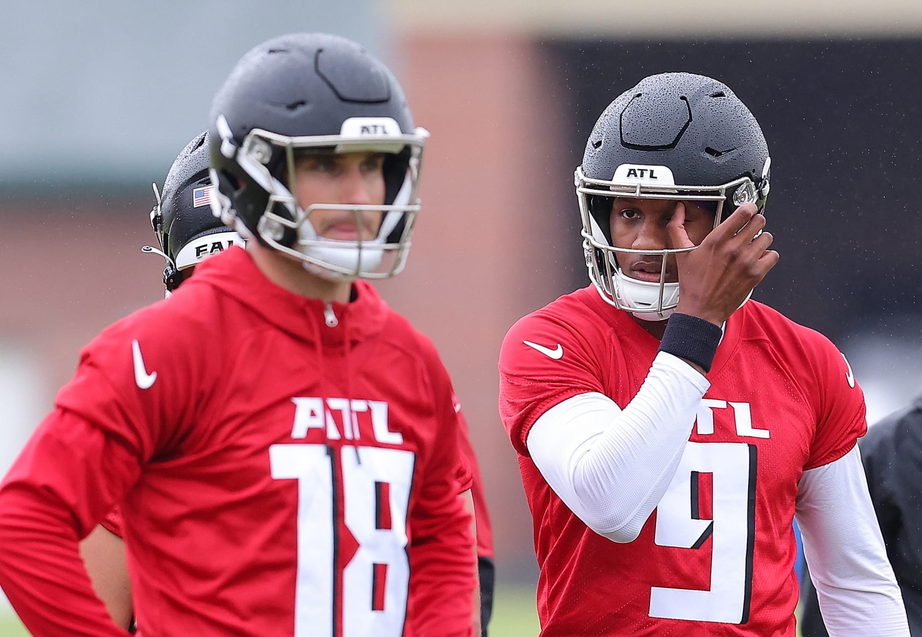 FLOWERY BRANCH, GEORGIA - MAY 14:  Quarterback Michael Penix Jr. #9 of the Atlanta Falcons looks on behind quarterback Kirk Cousins #18 during OTA offseason workouts at the Atlanta Falcons training facility on May 14, 2024 in Flowery Branch, Georgia. (Photo by Kevin C. Cox/Getty Images)