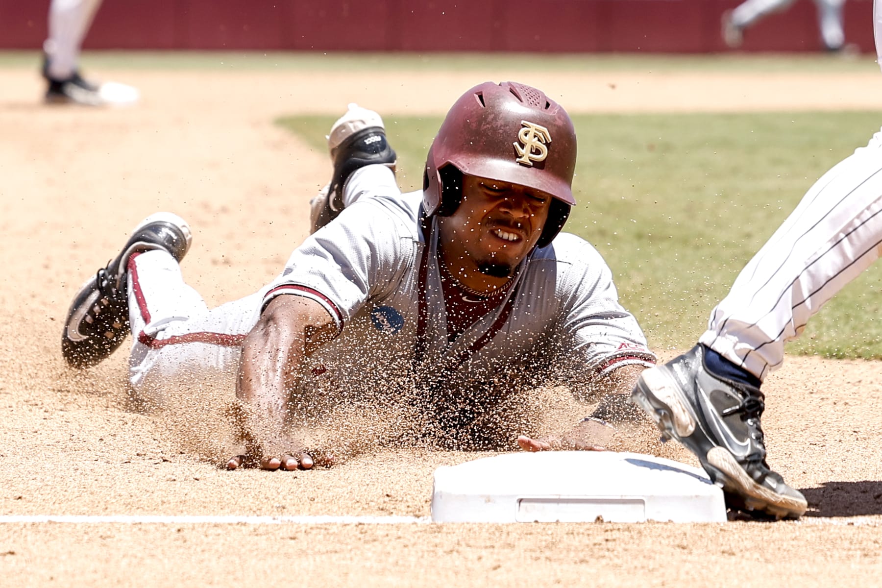 TALLAHASSEE, FL - JUNE 08: Outfielder Jordan Williams #12 of the Florida State Seminoles slides into third base during game 2 against the UConn Huskies in the 2024 NCAA Baseball Super Regional on Mike Martin Field at Dick Howser Stadium on June 8, 2024 in Tallahassee, Florida. The Seminoles defeated the UConn Huskies 10-8 in 12 innings to advance to the College World Series for the 24th time in the program history. (Photo by Don Juan Moore/Getty Images)