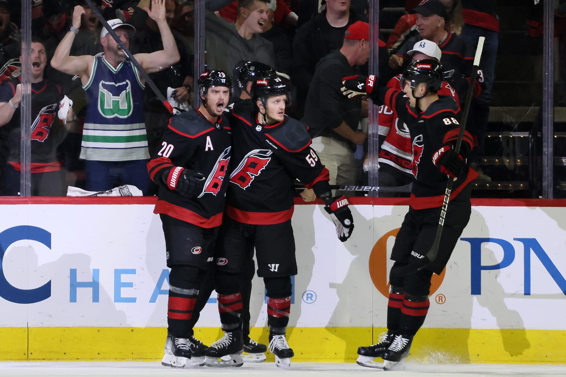RALEIGH, NORTH CAROLINA - MAY 11: Sebastian Aho #20 of the Carolina Hurricanes celebrates after scoring a goal against the New York Rangers with Jake Guentzel #59 and Martin Necas #88 during the first period in Game Four of the Second Round of the 2024 Stanley Cup Playoffs at PNC Arena on May 11, 2024 in Raleigh, North Carolina. (Photo by Bruce Bennett/Getty Images)