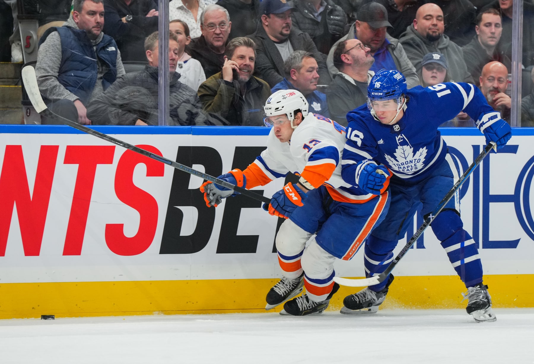 TORONTO, CANADA - FEBRUARY 05: Mathew Barzal #13 of the New York Islanders skates with the puck past Mitchell Marner #16 of the Toronto Maple Leafs during the first period at Scotiabank Arena on February 05, 2024 in Toronto, Ontario, Canada. (Photo by Chris Tanouye/Getty Images)