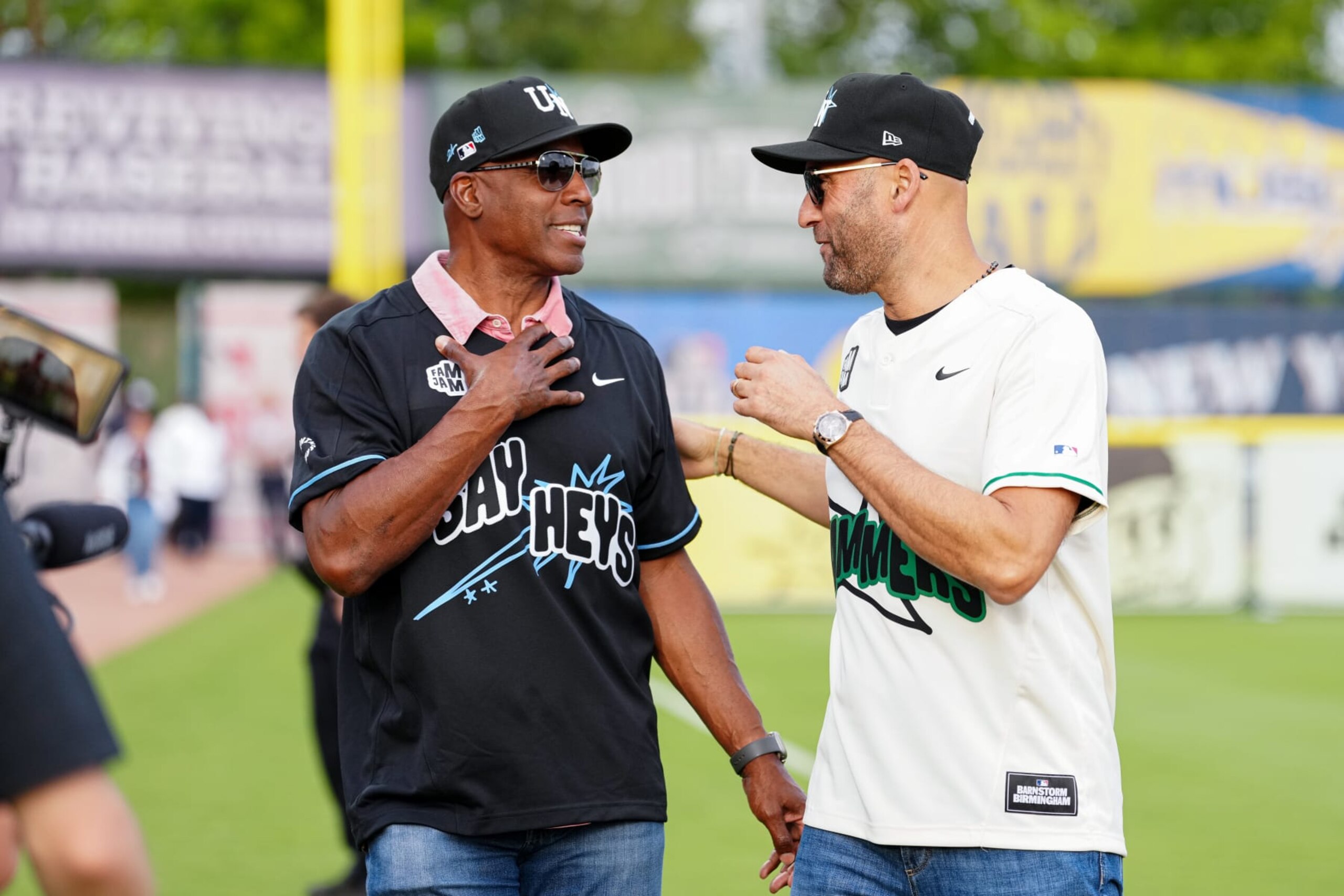 BIRMINGHAM, AL - JUNE 19: Former player Barry Bonds and MLB Hall of Famer Derek Jeter interact prior to the 2024 Barnstorm Birmingham Celebrity Softball Game between the Say Heys and the Hammers at Rickwood Field on Wednesday, June 19, 2024 in Birmingham, Alabama. (Photo by Mary DeCicco/MLB Photos via Getty Images)