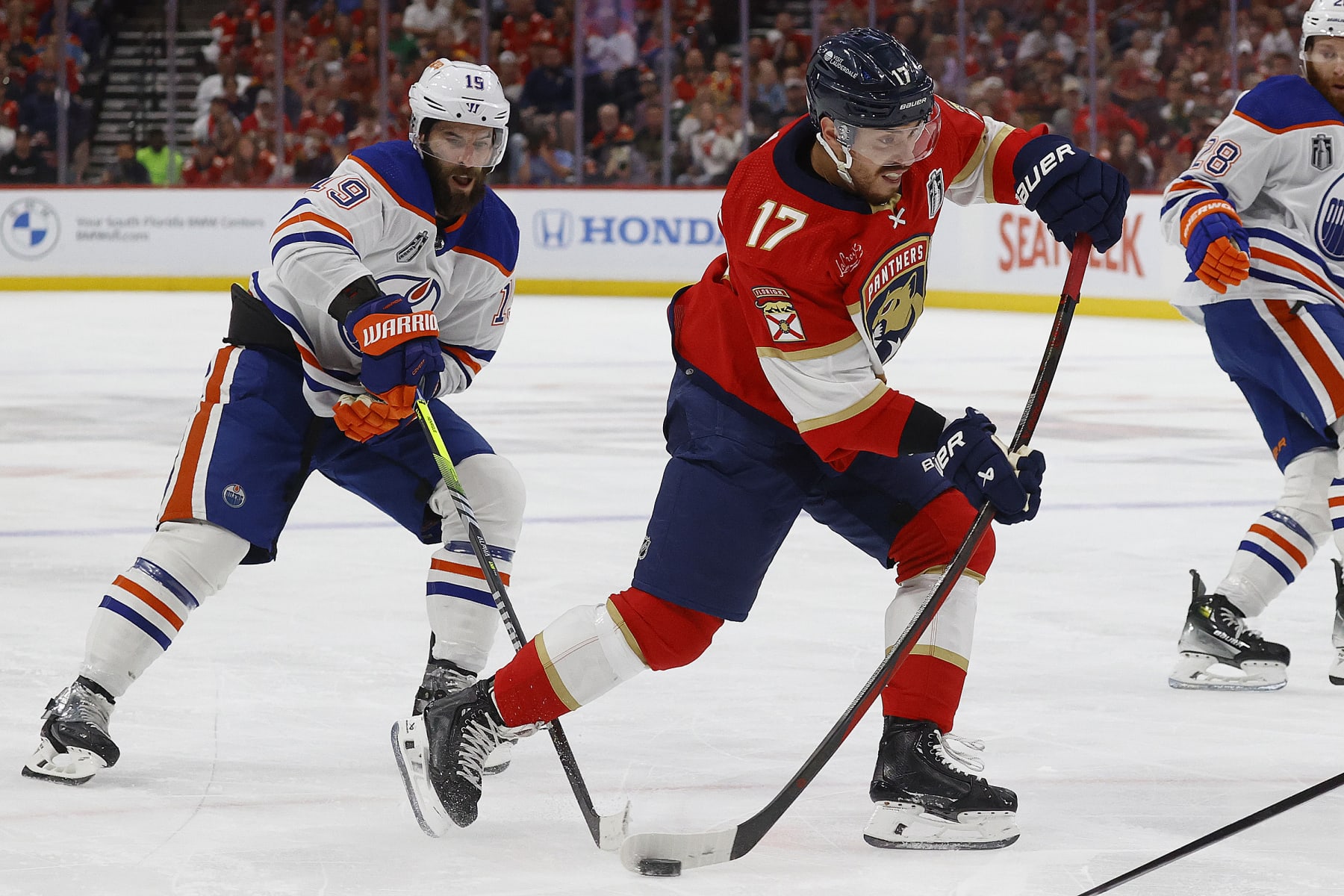 SUNRISE, FLORIDA - JUNE 18: Evan Rodrigues #17 of the Florida Panthers shoots the puck against Adam Henrique #19 of the Edmonton Oilers in Game Five of the Stanley Cup Final at the Amerant Bank Arena on June 18, 2024 in Sunrise, Florida. (Photo by Eliot J. Schechter/NHLI via Getty Images)