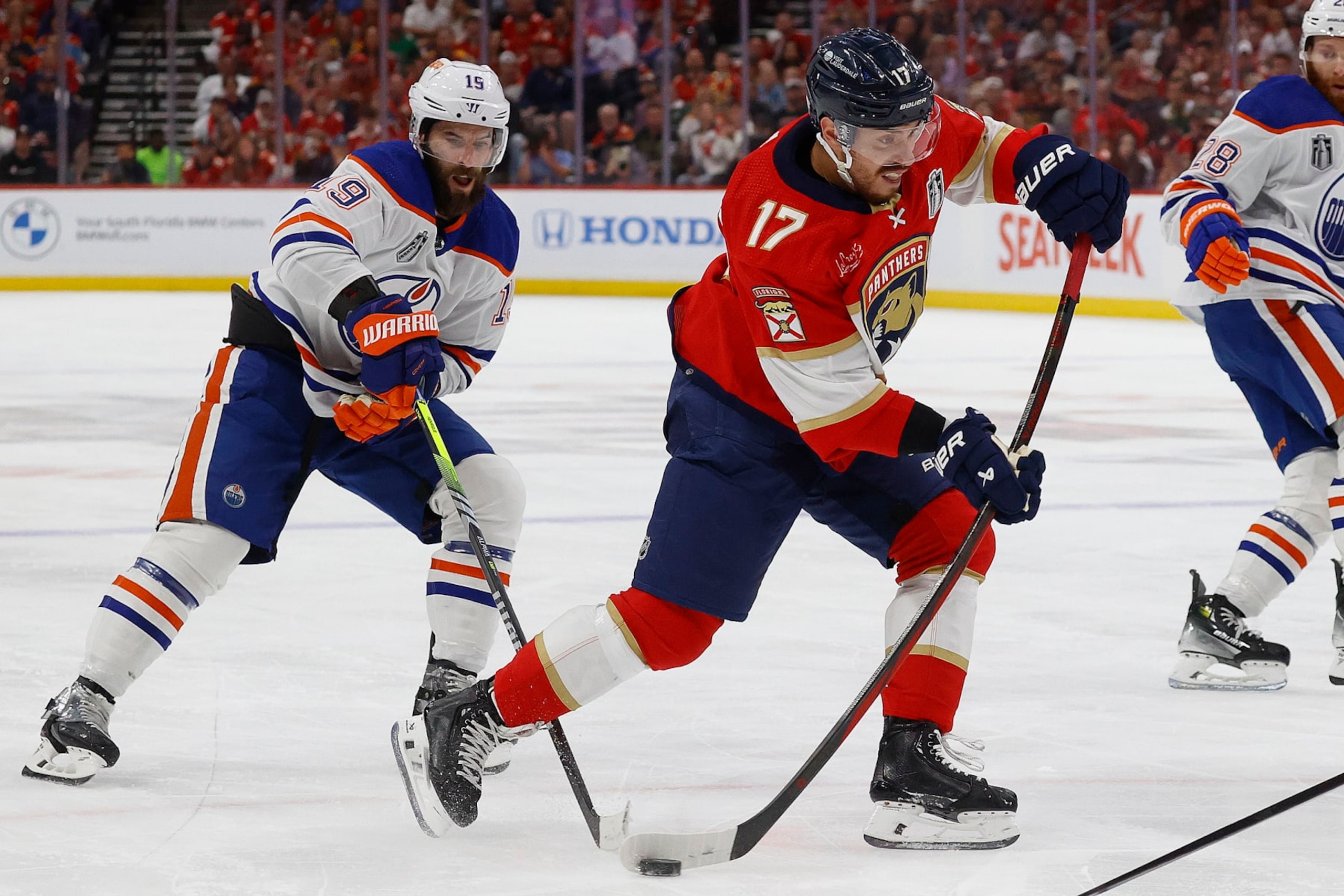 SUNRISE, FLORIDA - JUNE 18: Evan Rodrigues #17 of the Florida Panthers shoots the puck against Adam Henrique #19 of the Edmonton Oilers in Game Five of the Stanley Cup Final at the Amerant Bank Arena on June 18, 2024 in Sunrise, Florida. (Photo by Eliot J. Schechter/NHLI via Getty Images)
