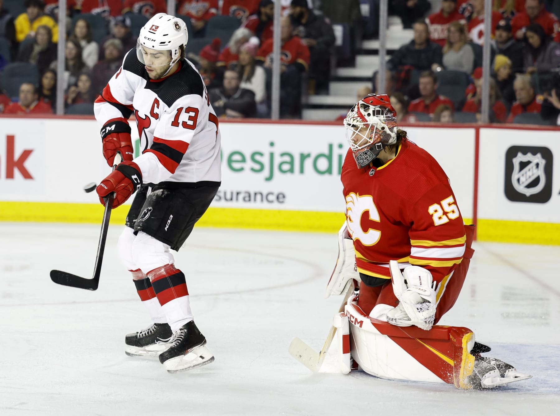 CALGARY, CANADA - NOVEMBER 05: Nico Hischier #13 of the New Jersey Devils tries to tip the puck in front of Jacob Markstrom #25 of the Calgary Flames at the Scotiabank Saddledome on November 5, 2022, in Calgary, Alberta, Canada. (Photo by Leah Hennel/Getty Images)
