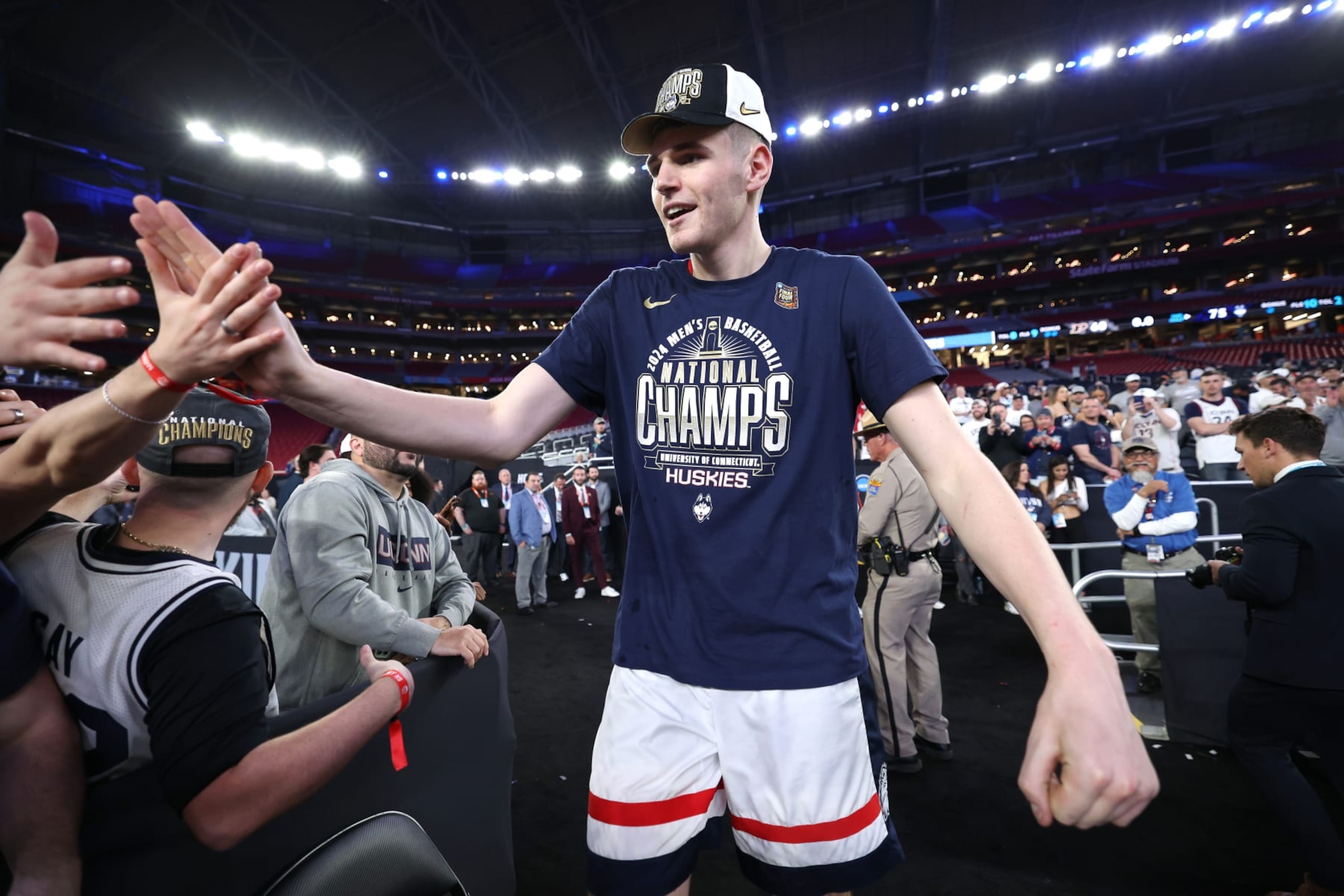 GLENDALE, ARIZONA - APRIL 08: Donovan Clingan #32 of the Connecticut Huskies celebrates with fans after beating the Purdue Boilermakers 75-60 to win the NCAA Men's Basketball Tournament National Championship game at State Farm Stadium on April 08, 2024 in Glendale, Arizona. (Photo by Jamie Squire/Getty Images)
