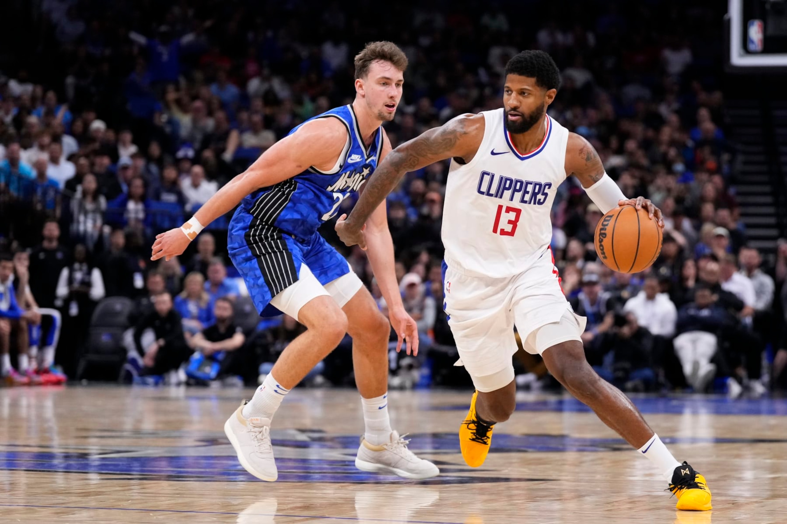 ORLANDO, FLORIDA - MARCH 29: Paul George #13 of the LA Clippers dribbles the ball against Franz Wagner #22 of the Orlando Magic during the fourth quarter at Kia Center on March 29, 2024 in Orlando, Florida. NOTE TO USER: User expressly acknowledges and agrees that, by downloading and or using this photograph, User is consenting to the terms and conditions of the Getty Images License Agreement. (Photo by Rich Storry/Getty Images)