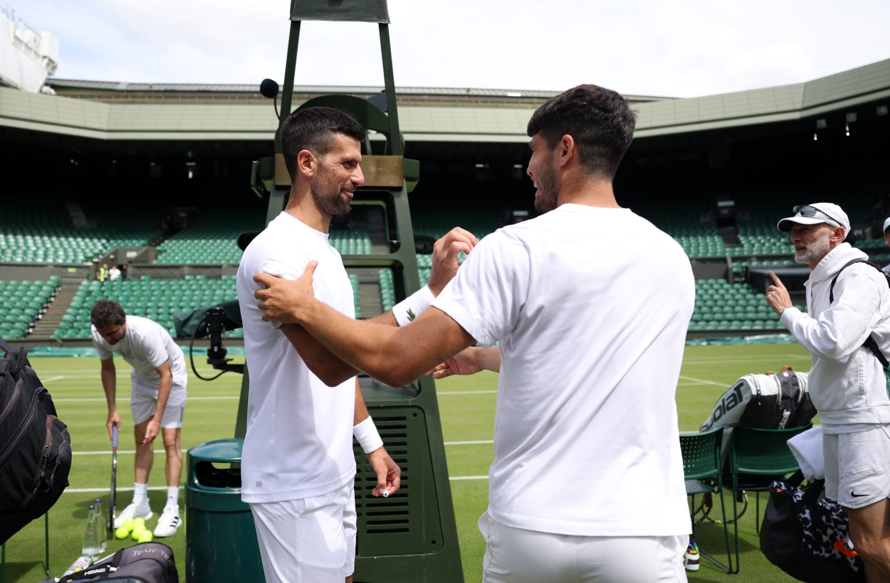 LONDON, ENGLAND - JUNE 27: Novak Djokovic (L) of Serbia greets Carlos Alcaraz of Spain during practice on centre court prior to The Championships Wimbledon 2024 at All England Lawn Tennis and Croquet Club on June 27, 2024 in London, England. (Photo by Clive Brunskill/Getty Images)