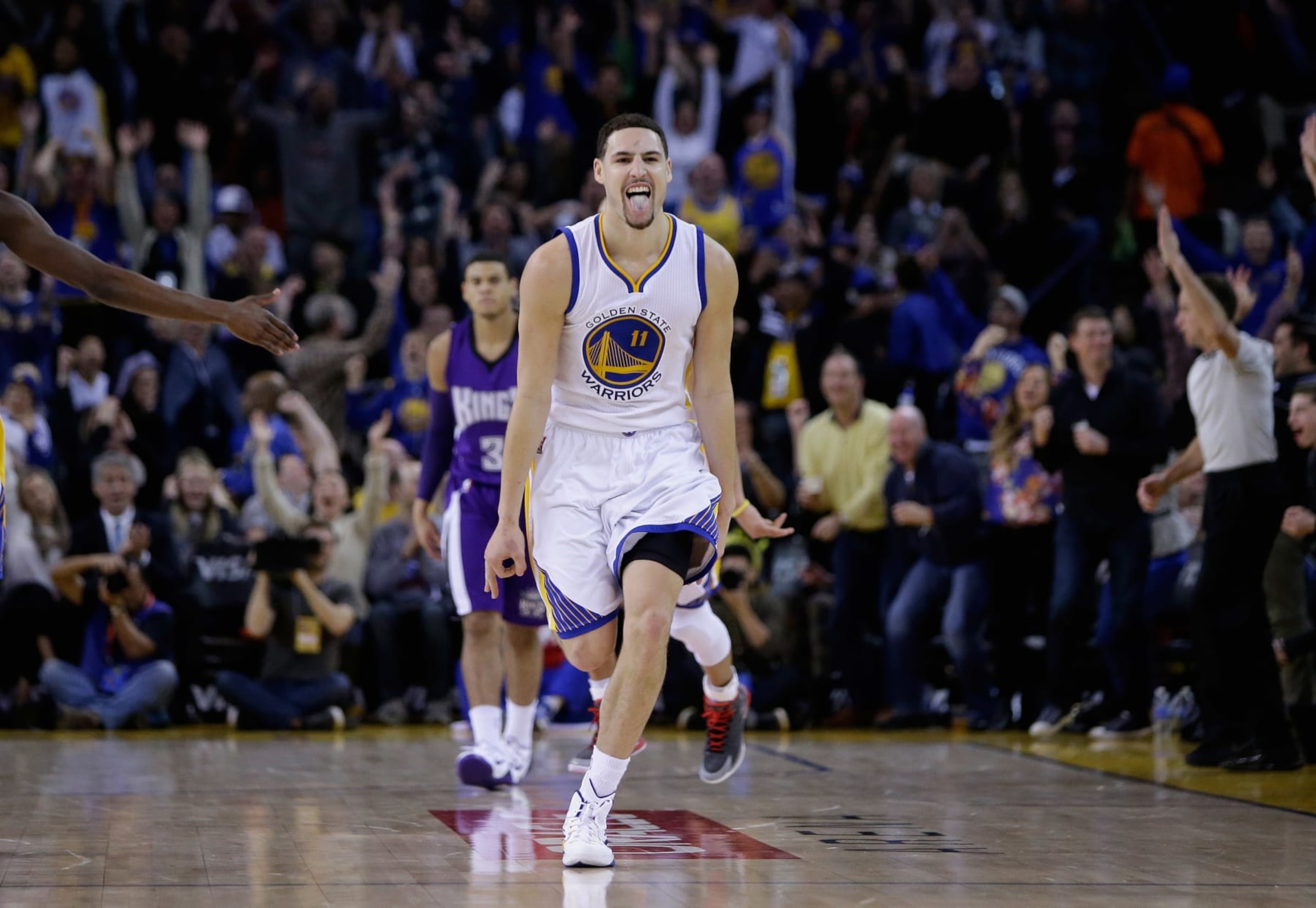 OAKLAND, CA - JANUARY 23:  Klay Thompson #11 of the Golden State Warriors reacts after he made a three-point basket in the third quarter of their game against the Sacramento Kings at ORACLE Arena on January 23, 2015 in Oakland, California. Thompson scored 37 points in the third quarter to set a NBA record. NOTE TO USER: User expressly acknowledges and agrees that, by downloading and or using this photograph, User is consenting to the terms and conditions of the Getty Images License Agreement.  (Photo by Ezra Shaw/Getty Images)